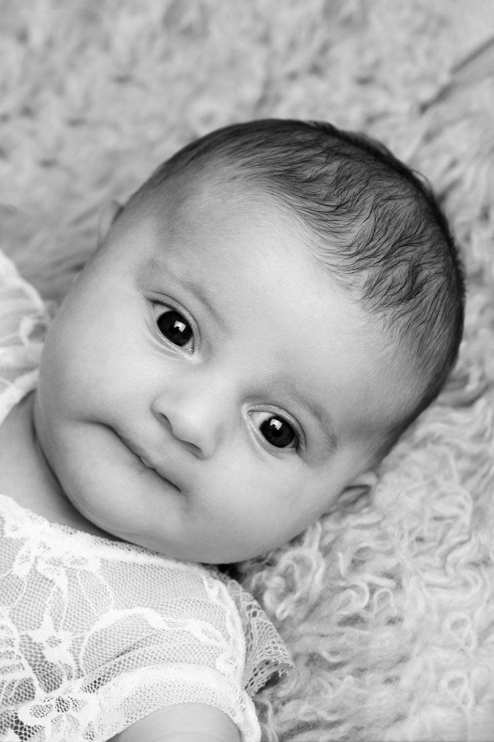 Black and white close-up portrait of baby with expressive eyes.