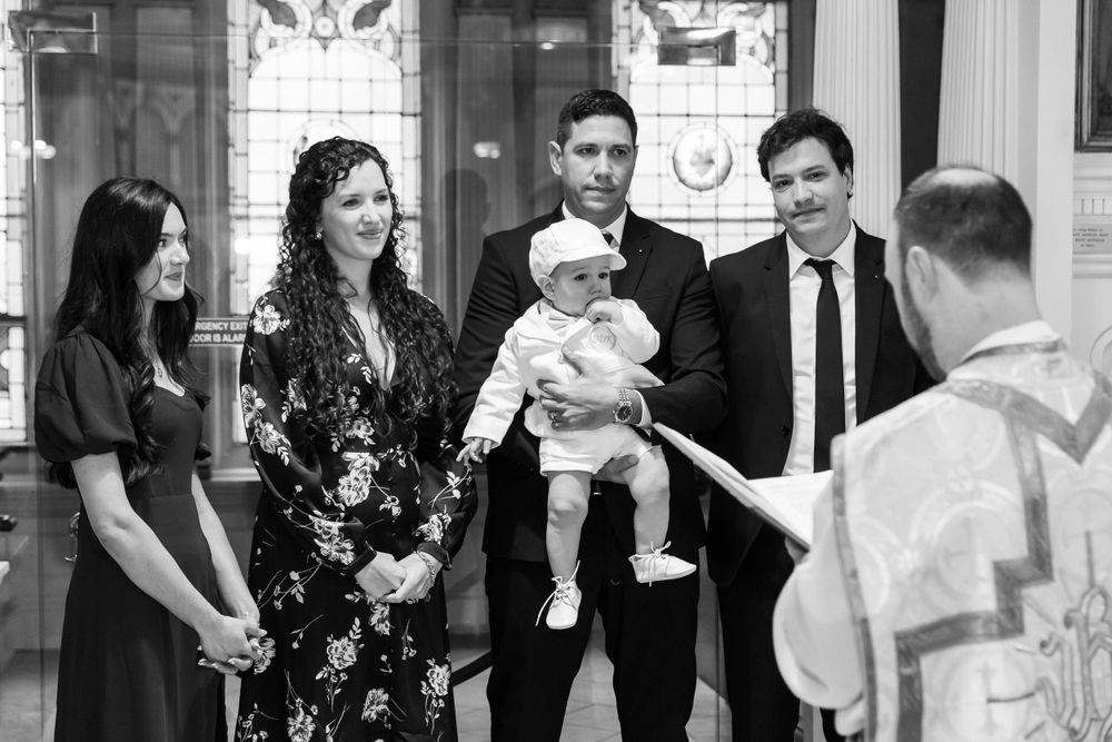 Black and white photo of baptism ceremony in ornate church interior.