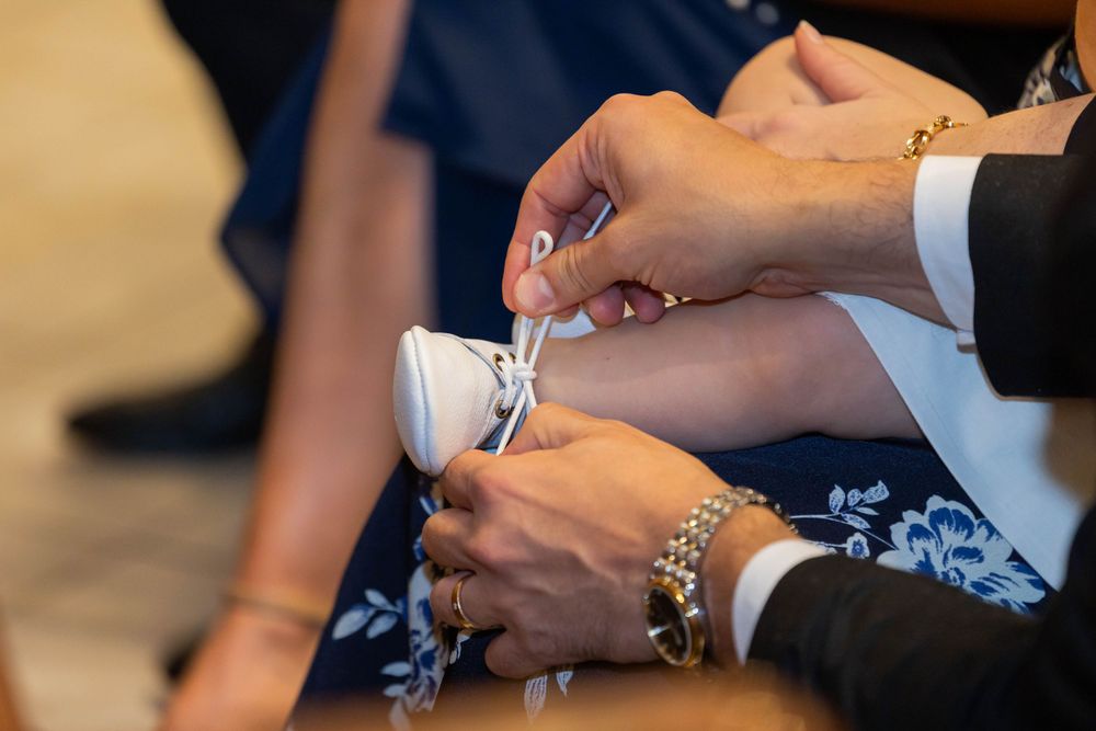 Close-up of hands preparing baptismal items during ceremony.