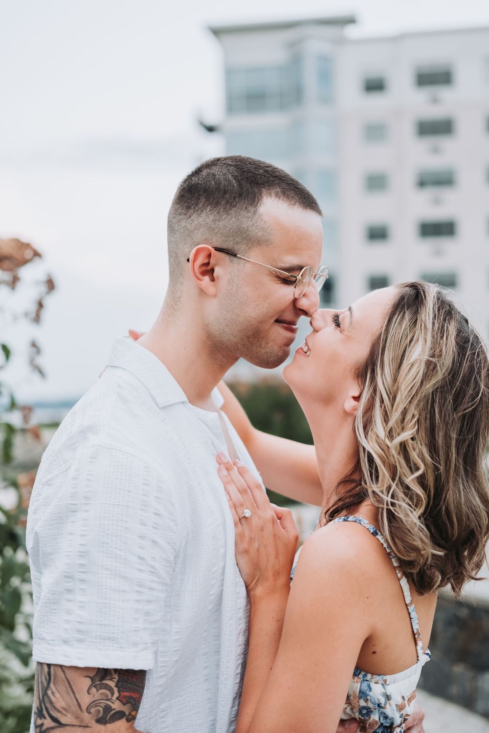 An engaged couple touches noses