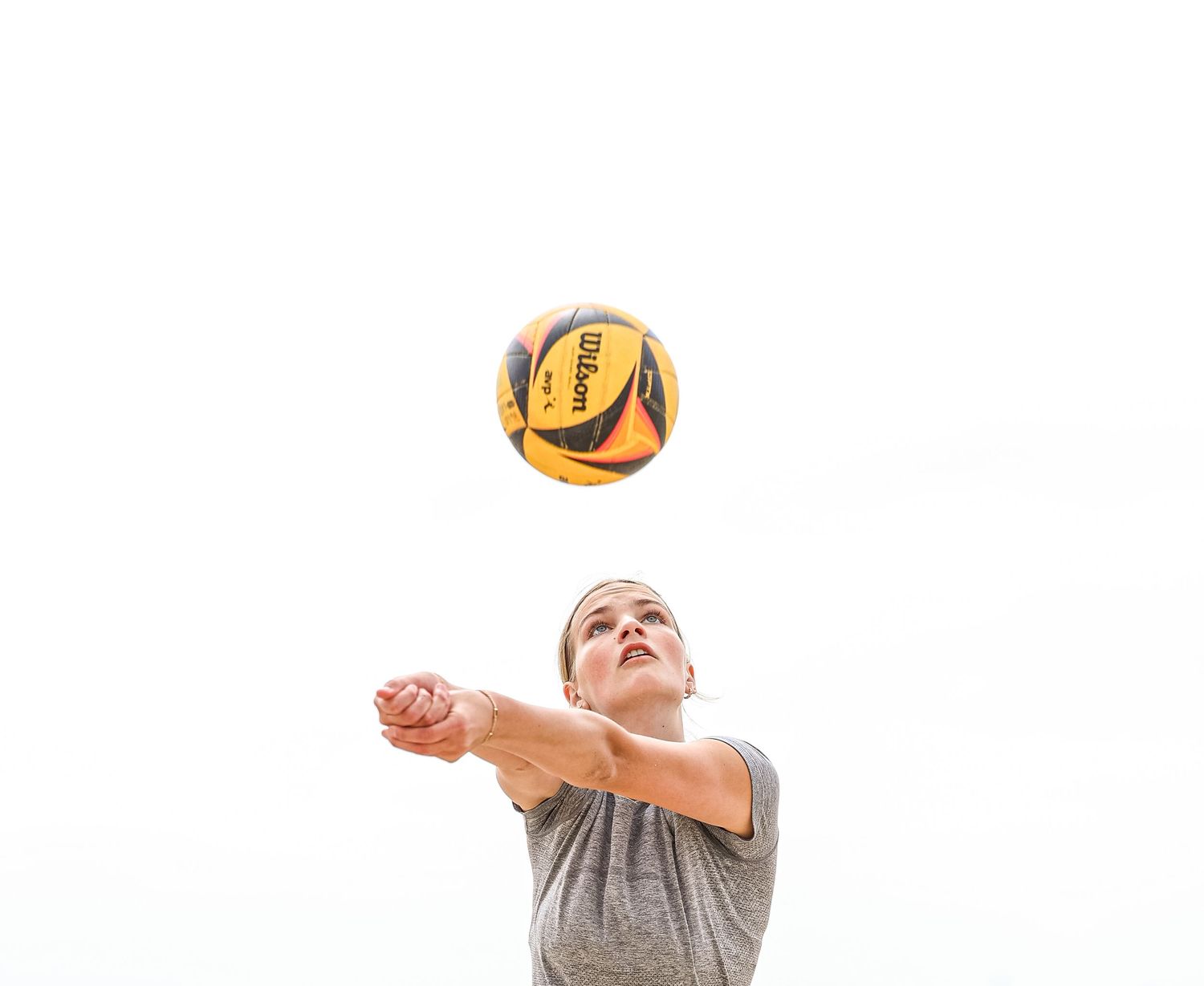 Beach volleyball player digs the ball during practice session.