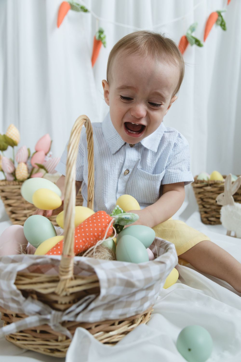 A joyful Easter scene with colorful eggs in wicker baskets, plush bunnies, and carrot garland decorations.