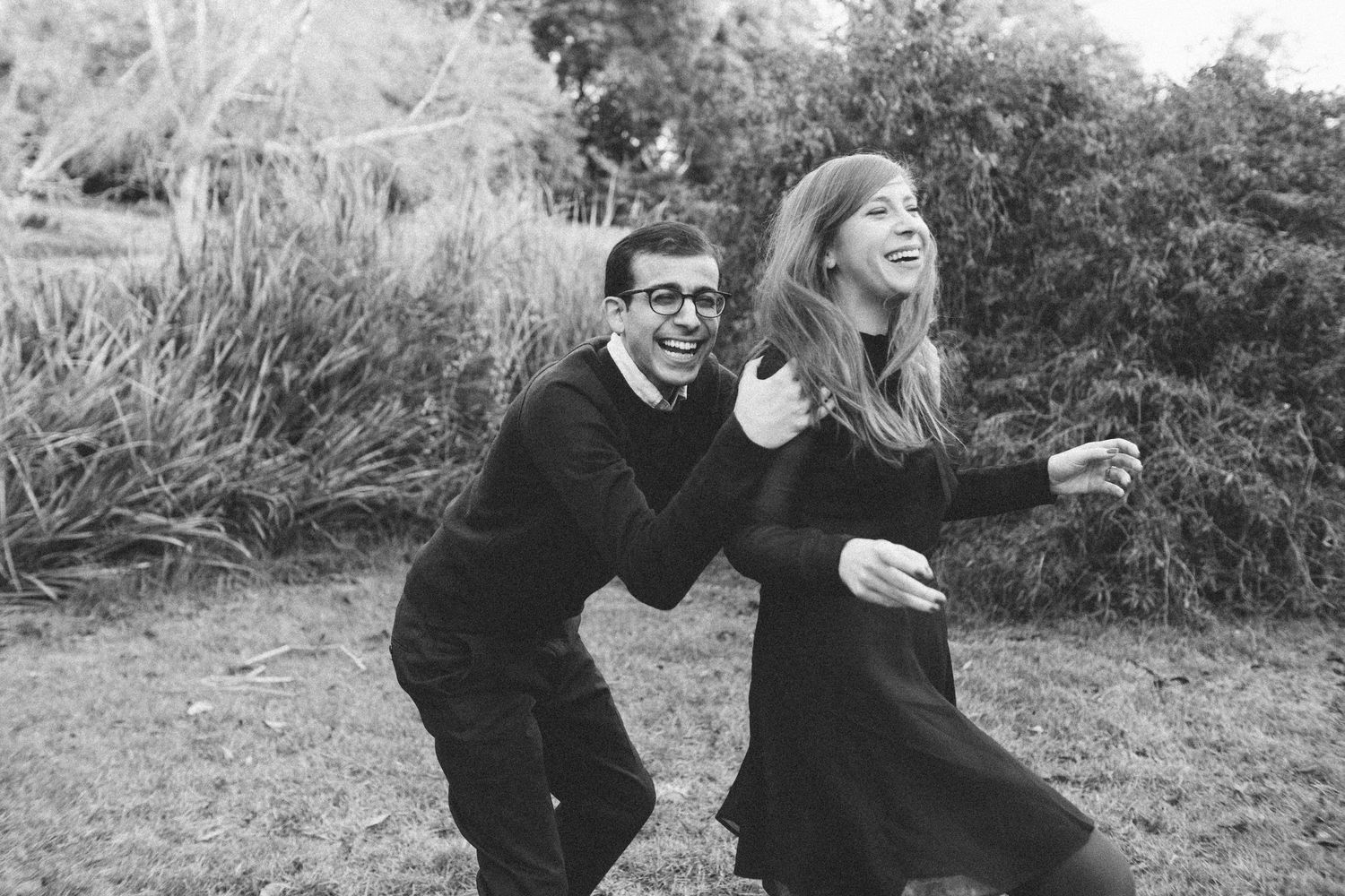 couple laughing and dancing together in nature, black and white