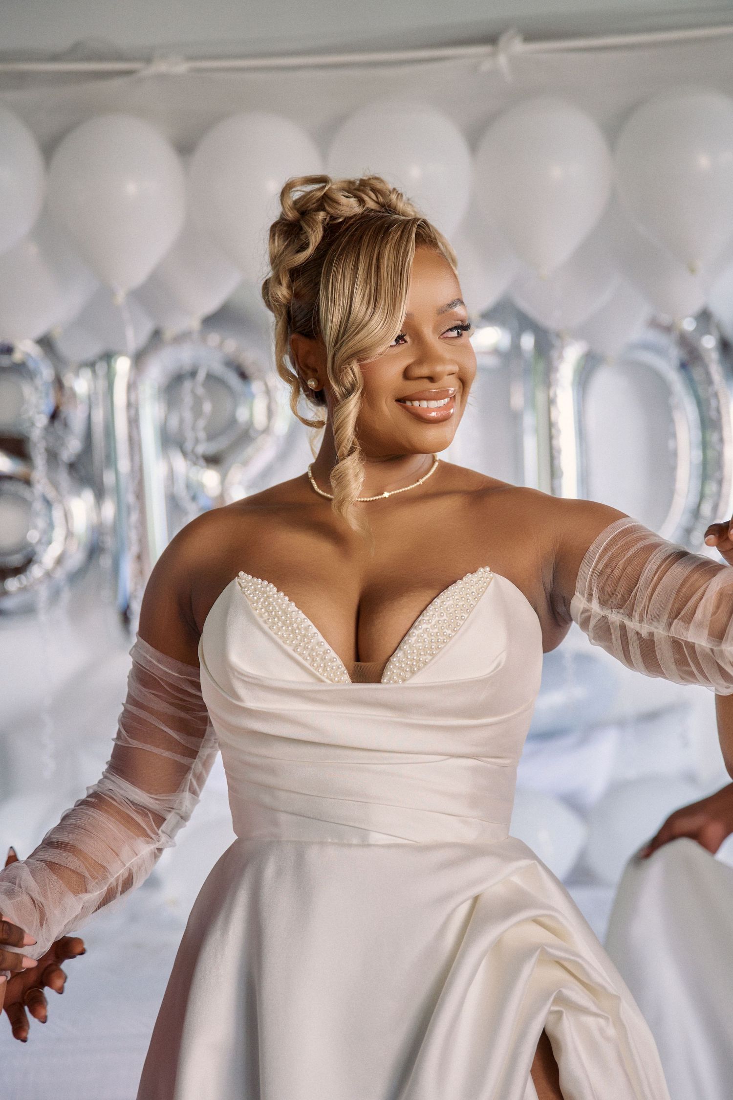 A person in an elegant white wedding dress dances joyfully against a background of silver Jamaica Wedding Photographer