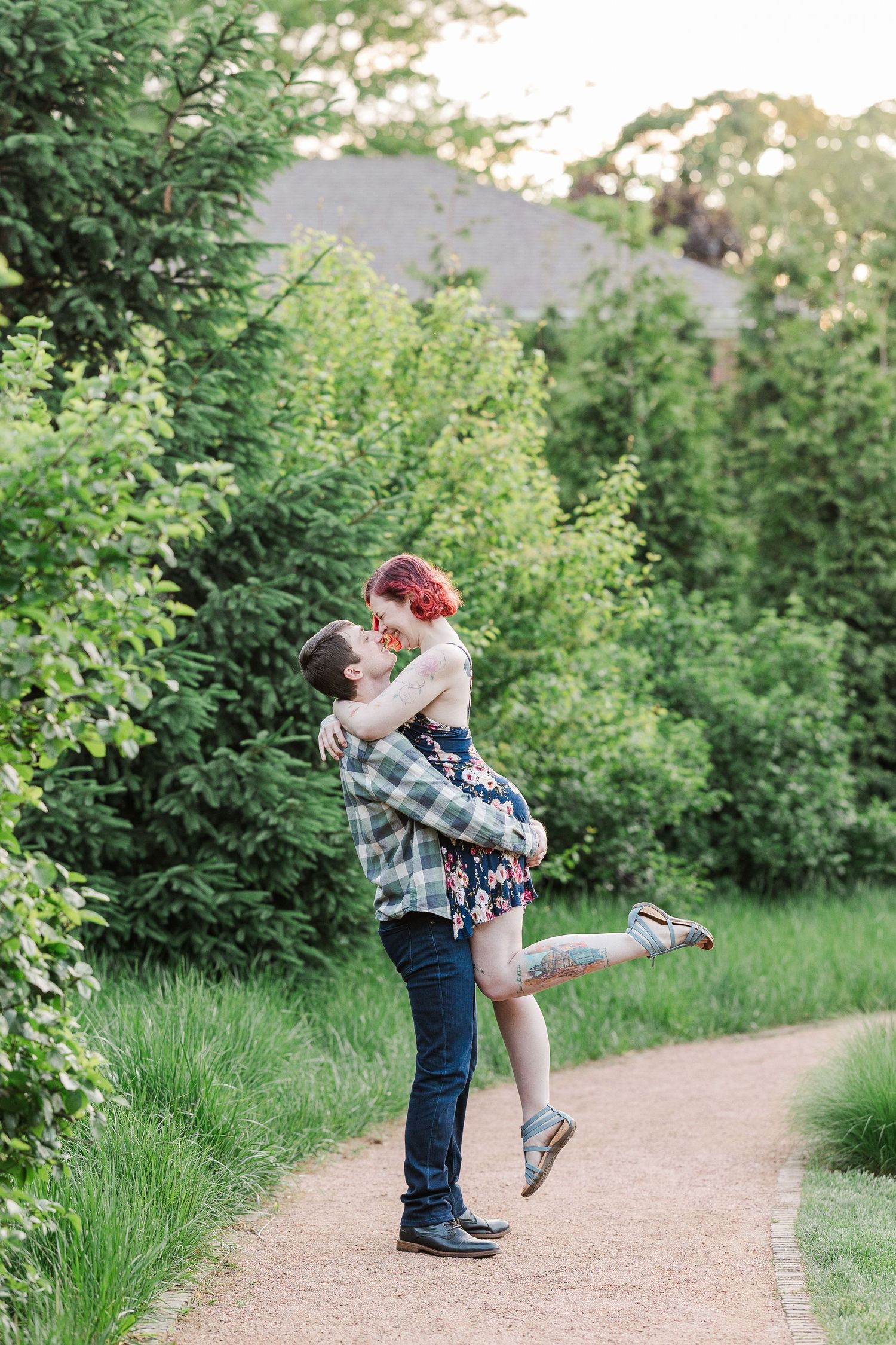 A romantic embrace on a garden path surrounded by lush green foliage during golden hour at Cantigny Park