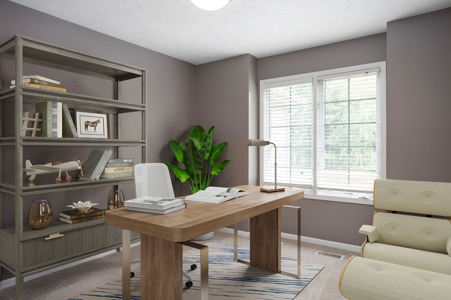 Virtually staged home office with wood desk, modern decor, bookshelves, large window, neutral tones, and natural light workspace.
