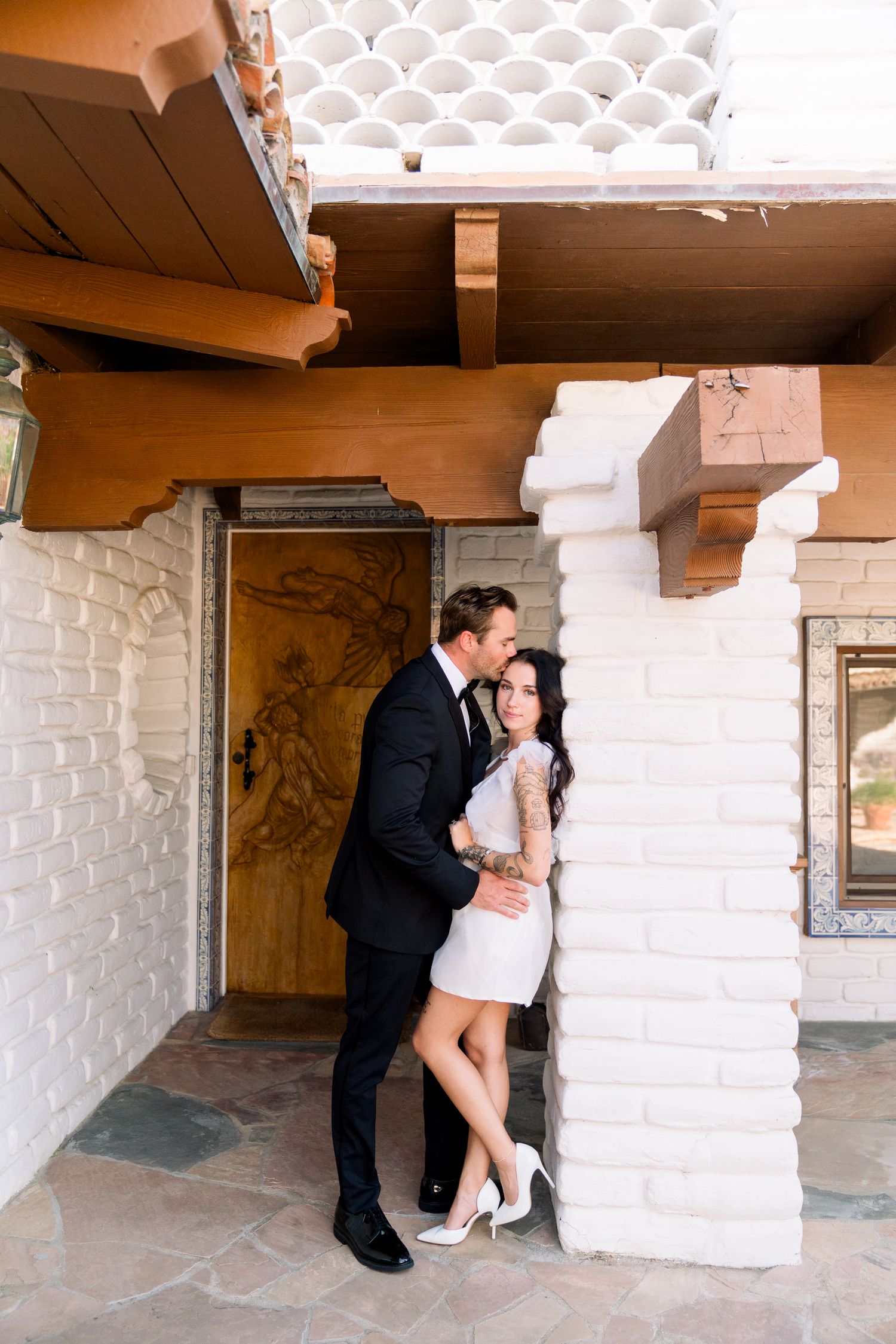 Interior scene showing Spanish colonial architecture with white stucco walls and decorative ceiling details.