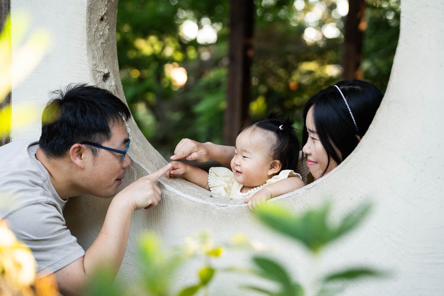 A touching moment between family of three silhouetted against warm outdoor lighting during a romantic evening.