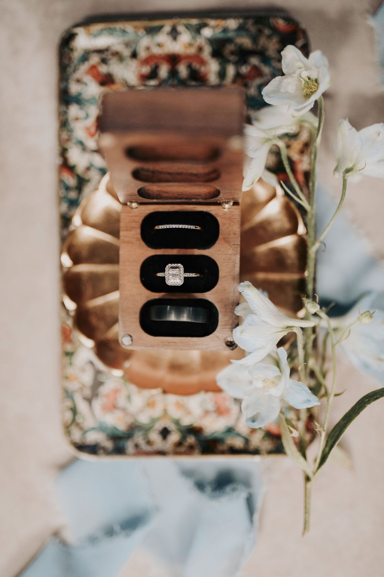 Close-up of invitation suite with velvet ring box and pressed flowers