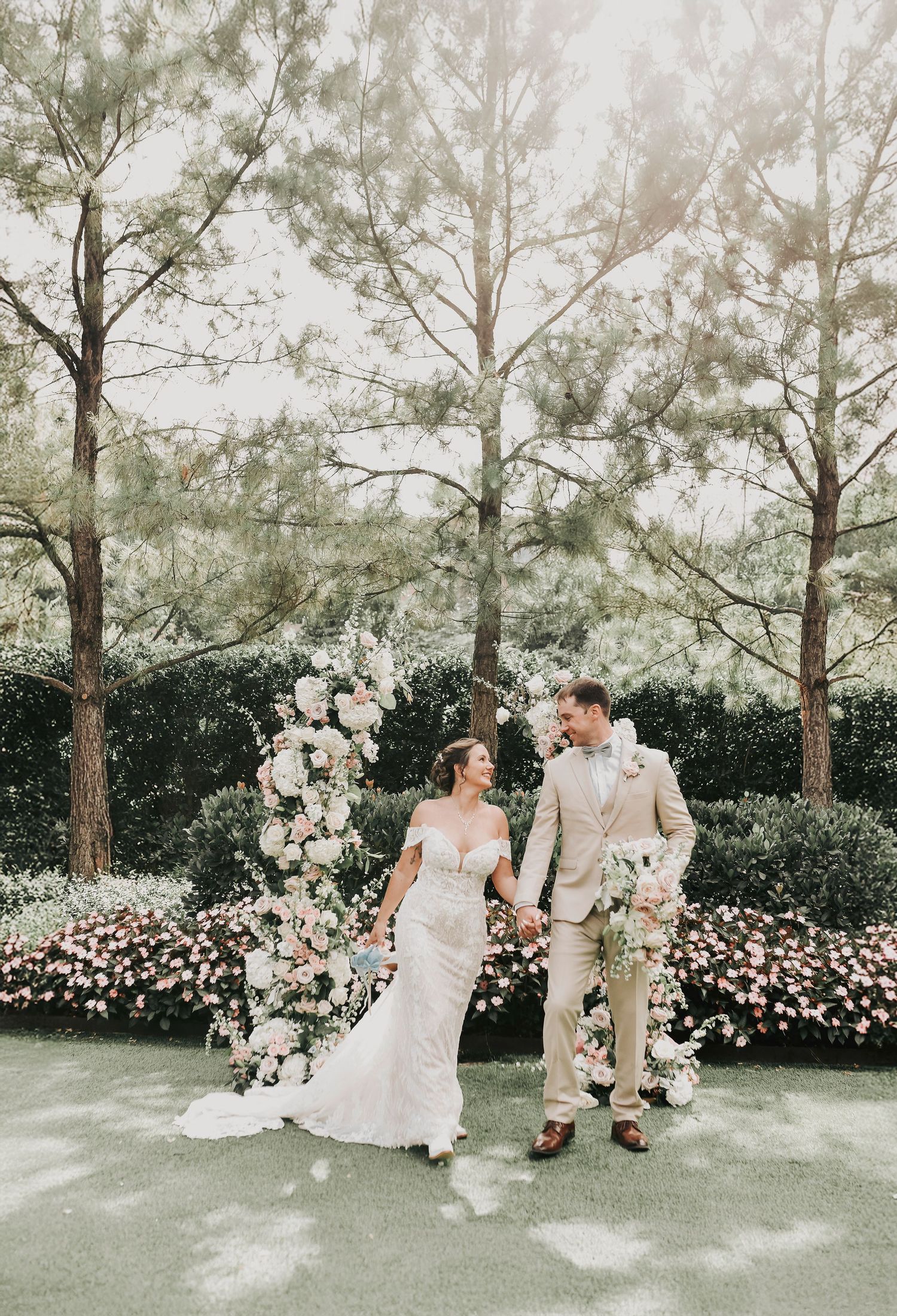 The garden at the drover hotel in the fort worth stockyards is the setting for a beautiful bride and groom walking together hand in hand