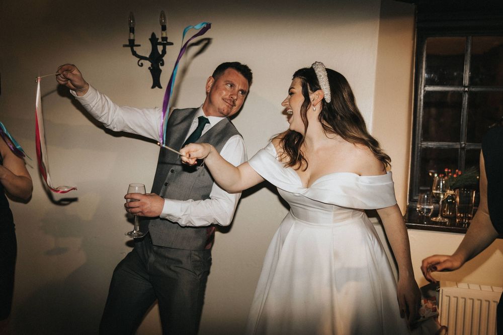 A couple takes their first dance together at an intimate wedding reception in a dimly lit venue.