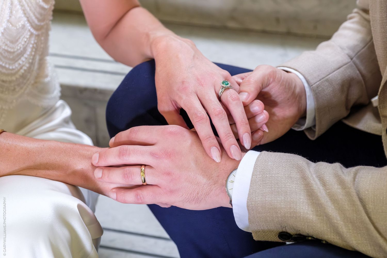 Close-up view of hands holding engagement ring during marriage proposal on outdoor steps.