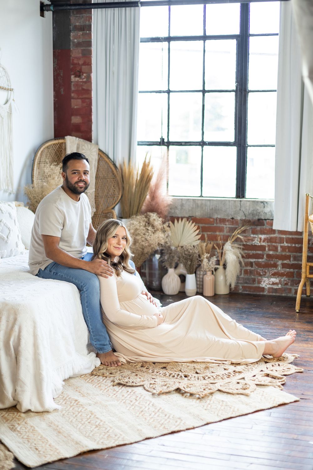 Maternity photo of couple in industrial loft setting with boho decor.