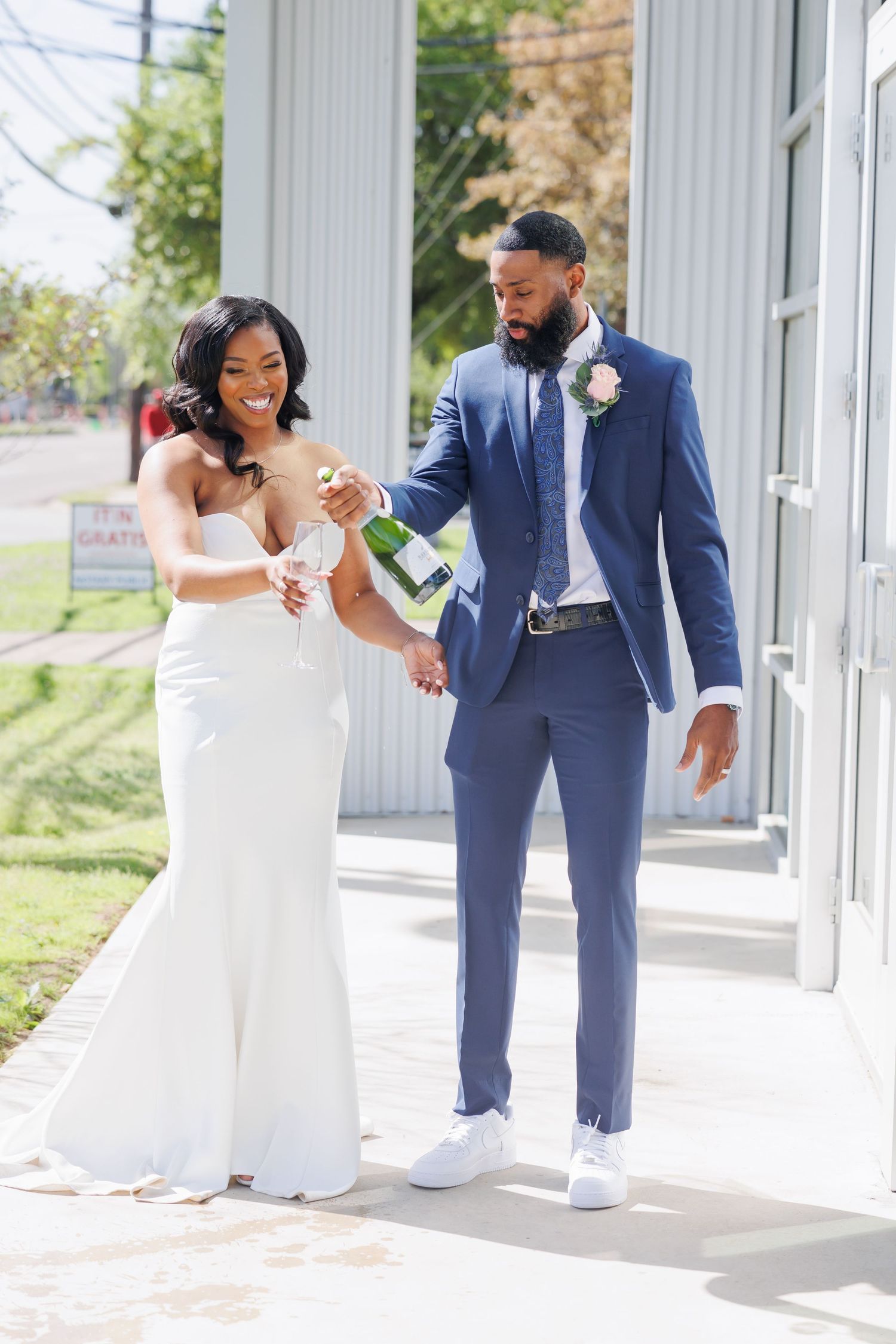 Romantic couple sharing tender moments during their outdoor wedding in a lush garden adorned with colorful tropical flowers and greenery.