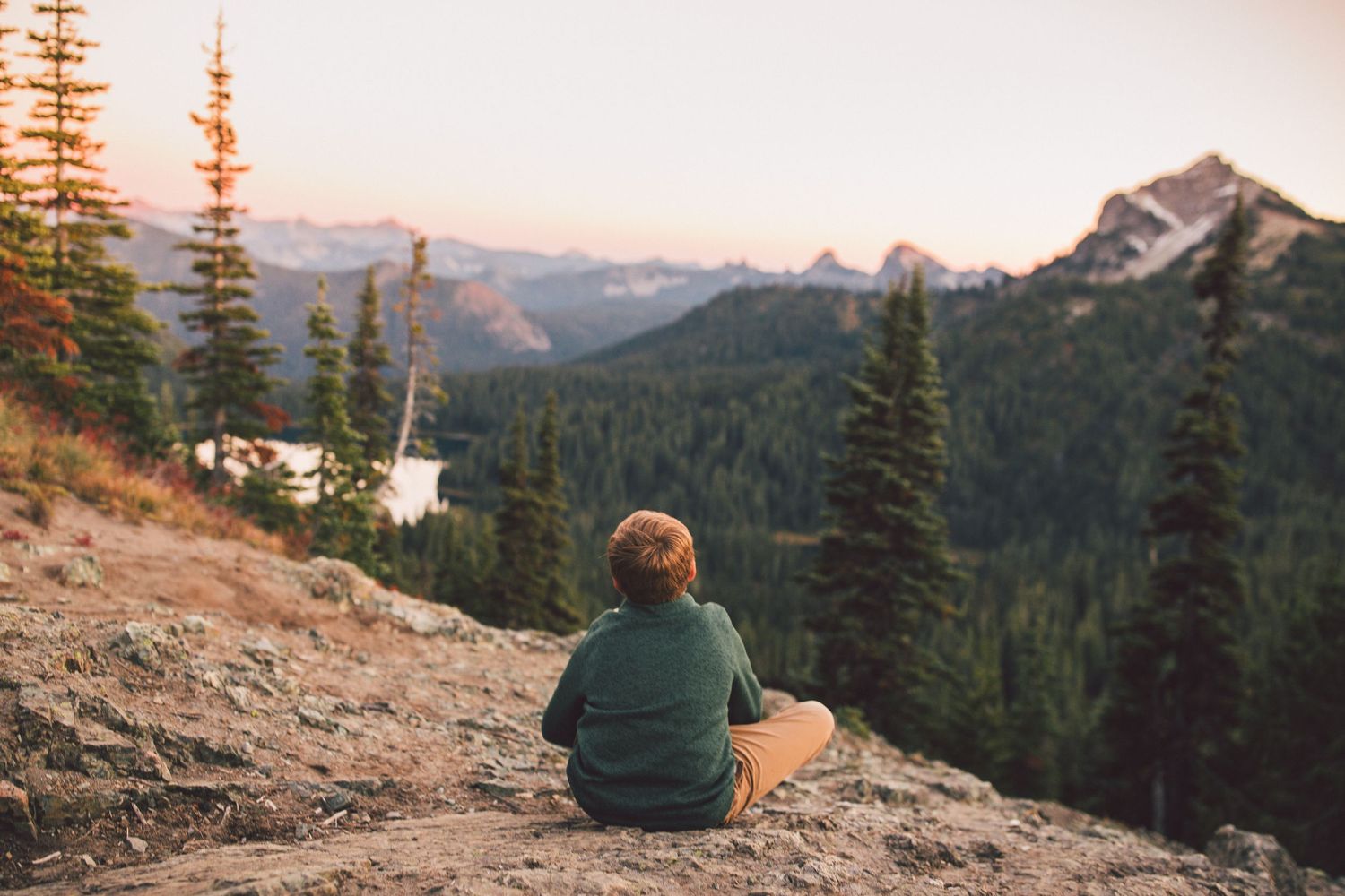 Child looking out over the mountain range at sunset during a family photoshoot in Mt. Rainier National Park in Washington