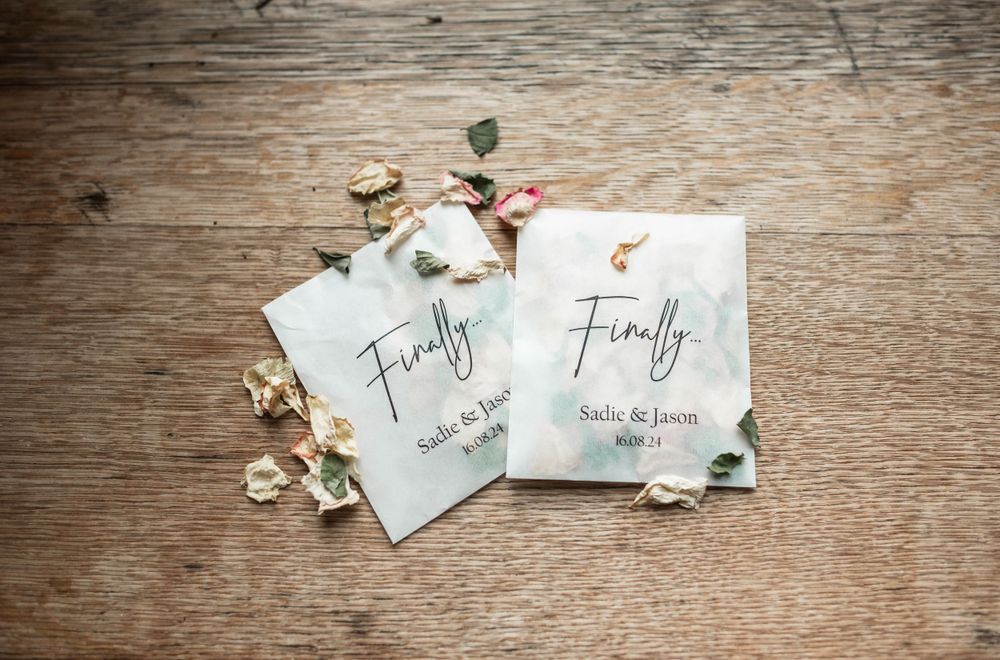 Two wedding invitations with 'Finally' text displayed on rustic wooden background.