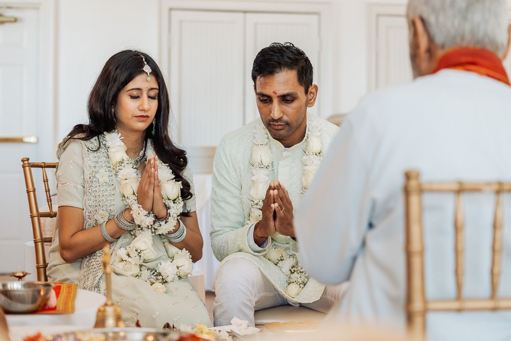 Spiritual ceremony with participants wearing traditional white and cream outfits performing prayers.