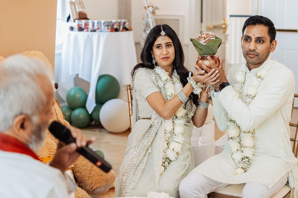Ceremonial moment with participants holding traditional offerings during an Indian wedding ritual.