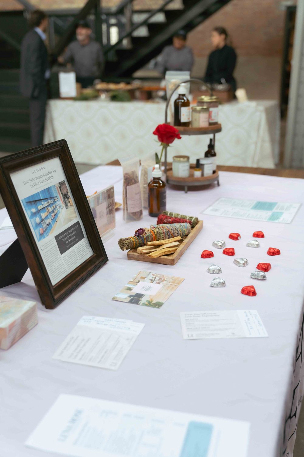 Event registration table with framed photos, papers, and decorative items at an indoor venue. At Fairlie, Chicago