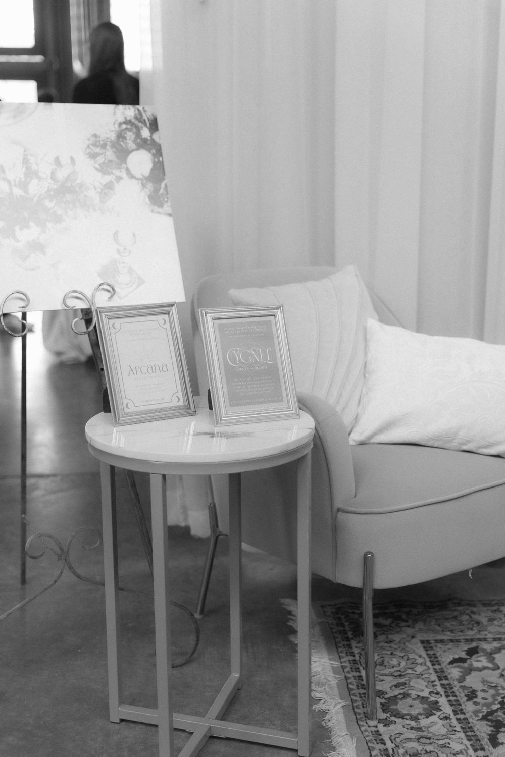 Minimalist white seating area with small side table and framed artwork in black and white. At Fairlie, Chicago