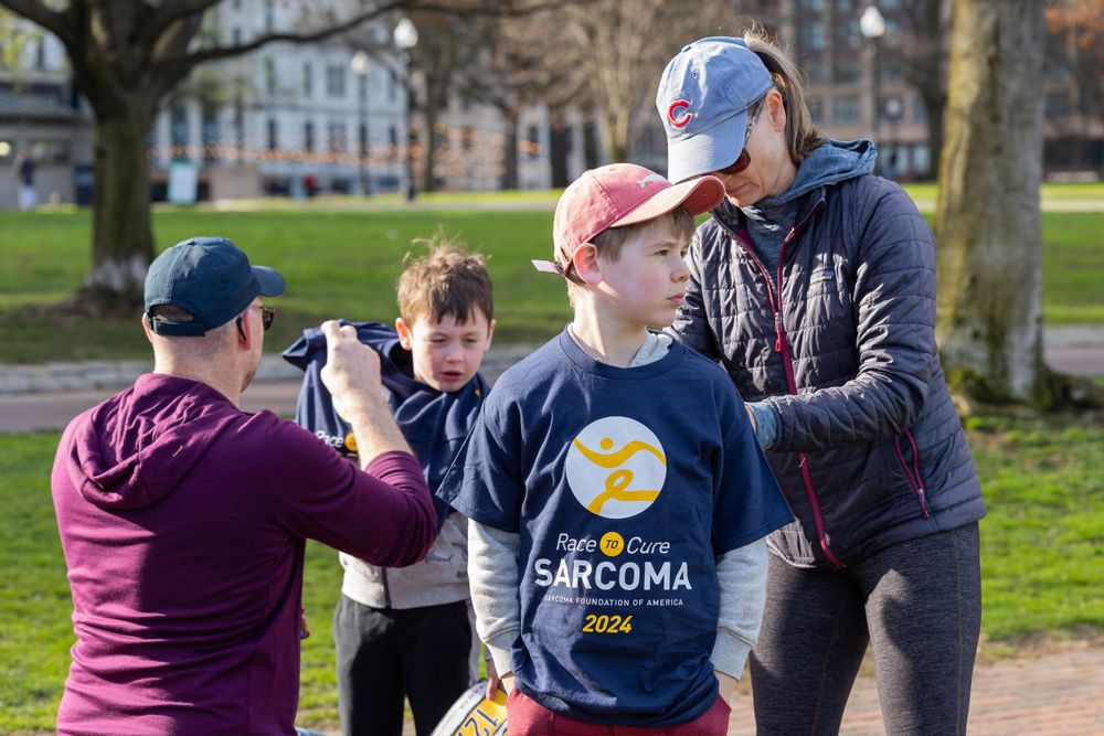 Group participating in fundraising activities at an outdoor sarcoma awareness event.
