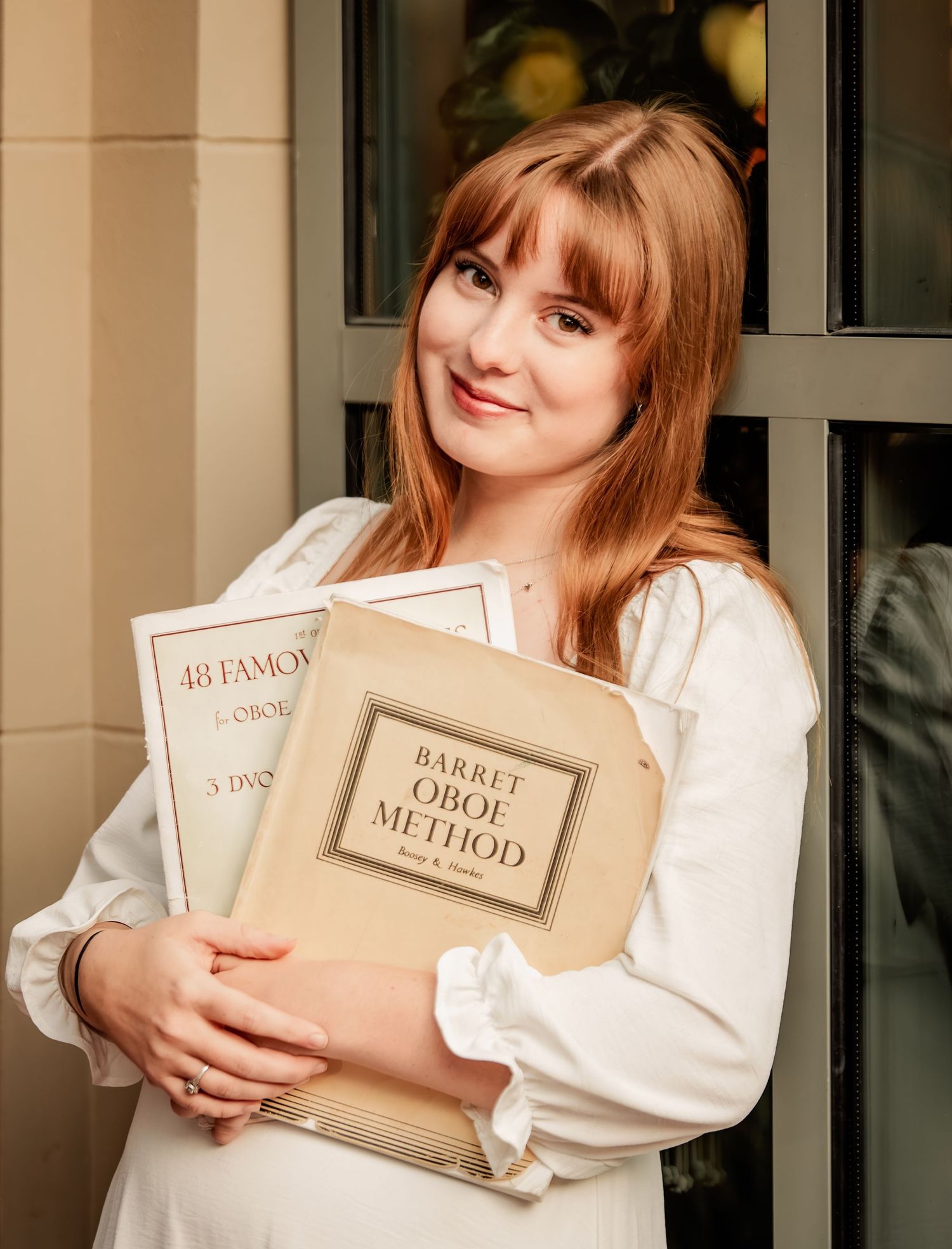 Someone in a white top holds vintage books including 'Rabbit Foot Method' in a low-lit indoor setting.