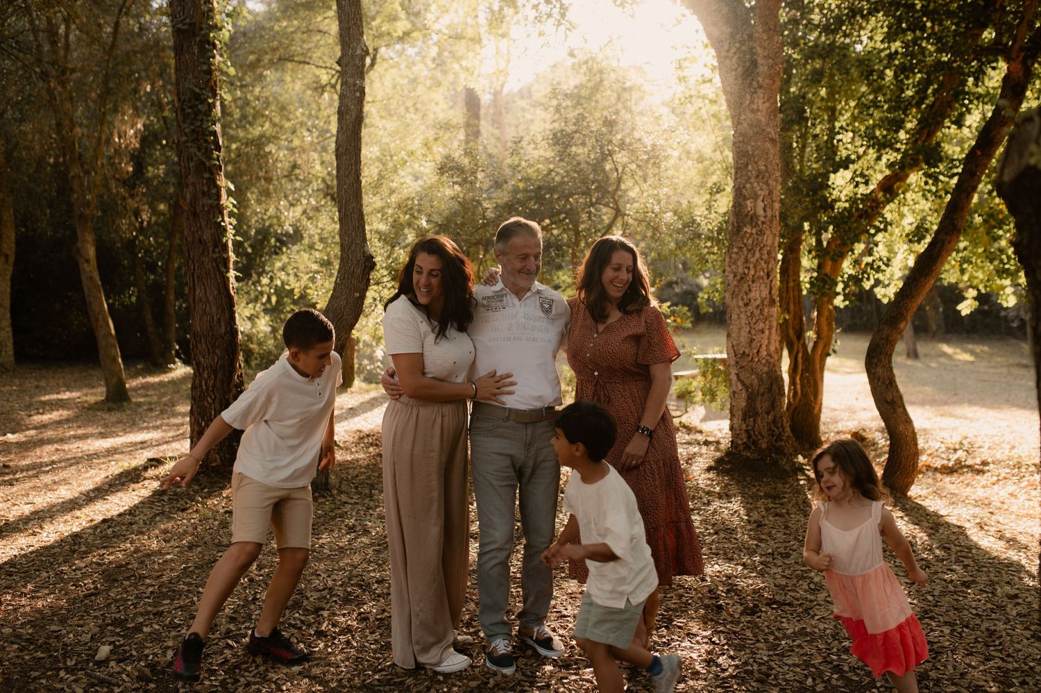 Photo d'une famille dont les enfants courent autour d'eux dans la forêts