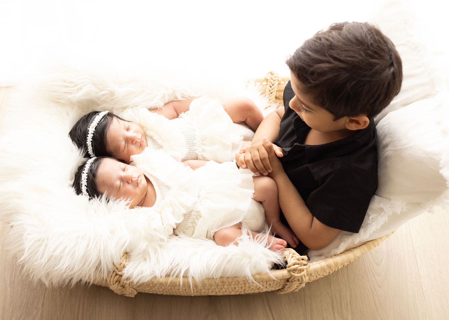 Elizabeth Lang Photography. Twin newborn photography Surrey. Brother admires his new sisters