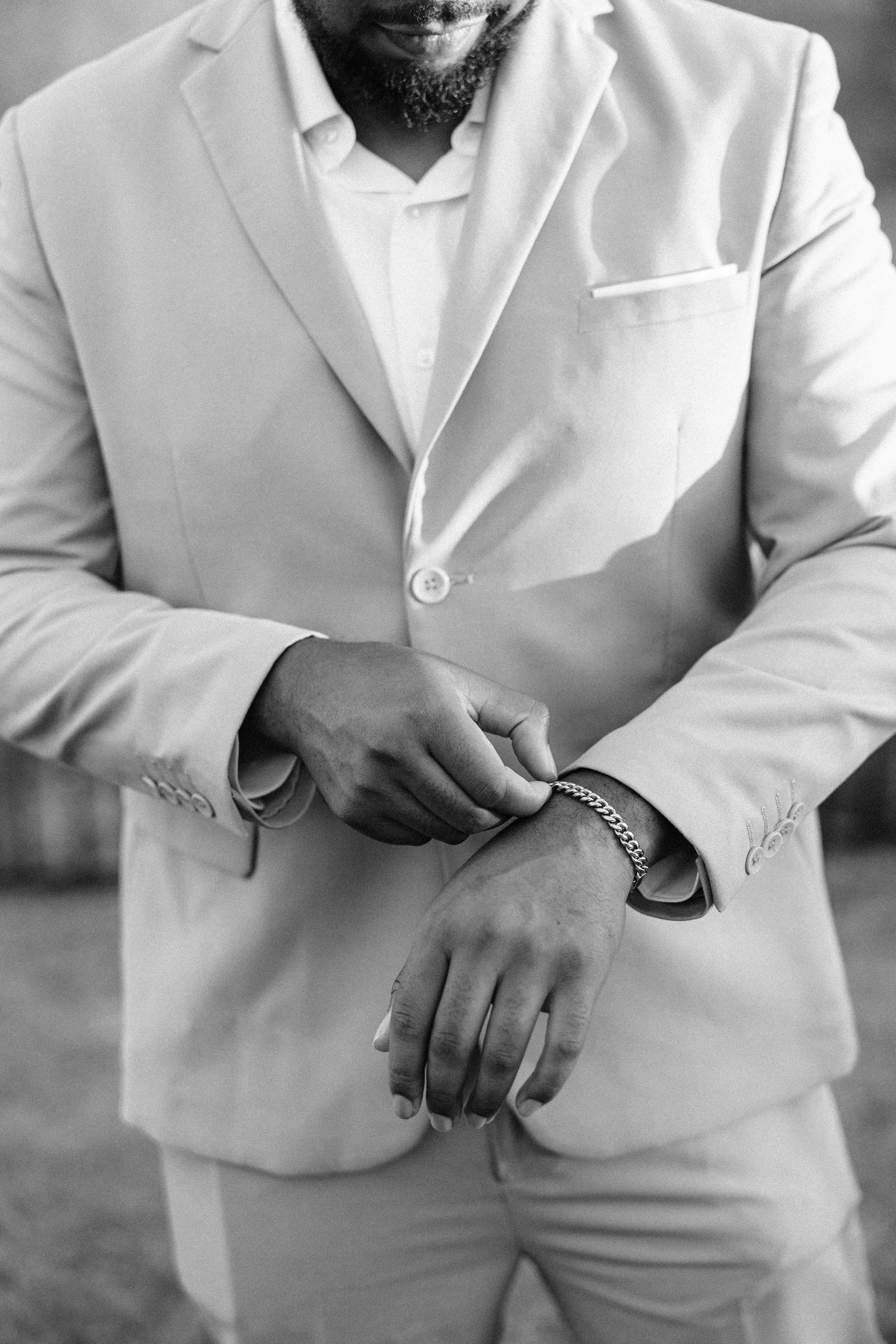 Groom adjusting tie while getting ready for backyard summer wedding in Fort Worth, Texas