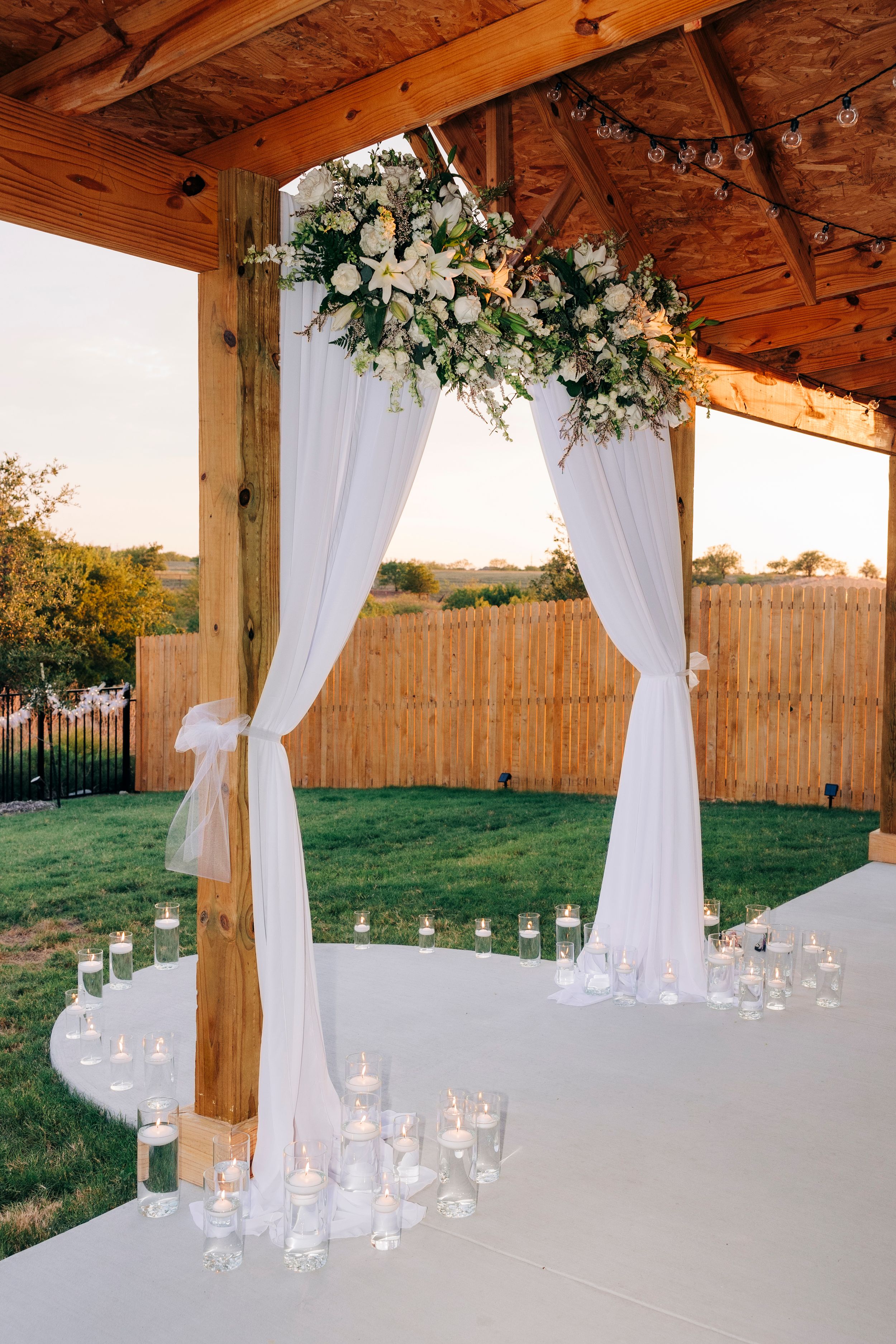 Bride holding white floral and greenery bouquet at backyard summer wedding in Fort Worth, Texas