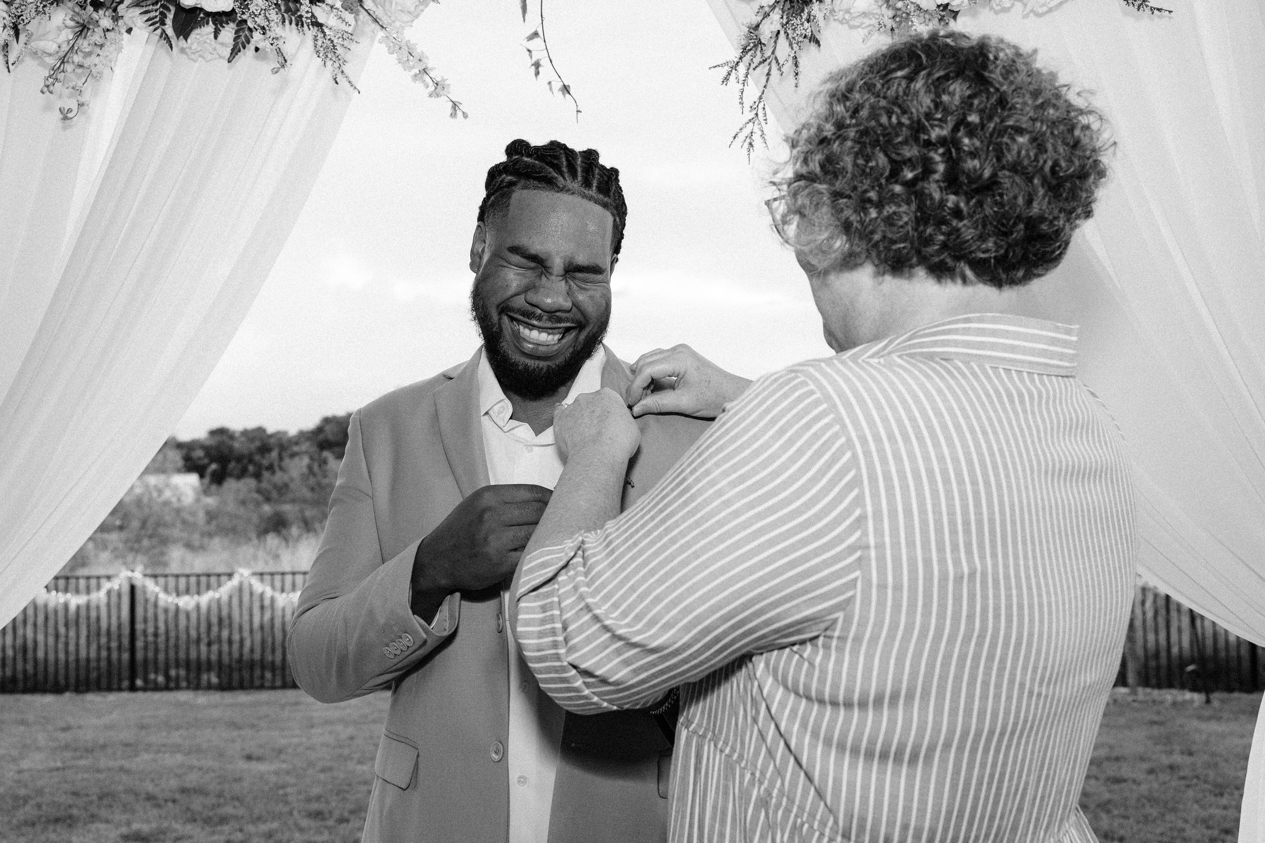 Close-up of groom’s boutonniere with white florals and greenery at Fort Worth wedding