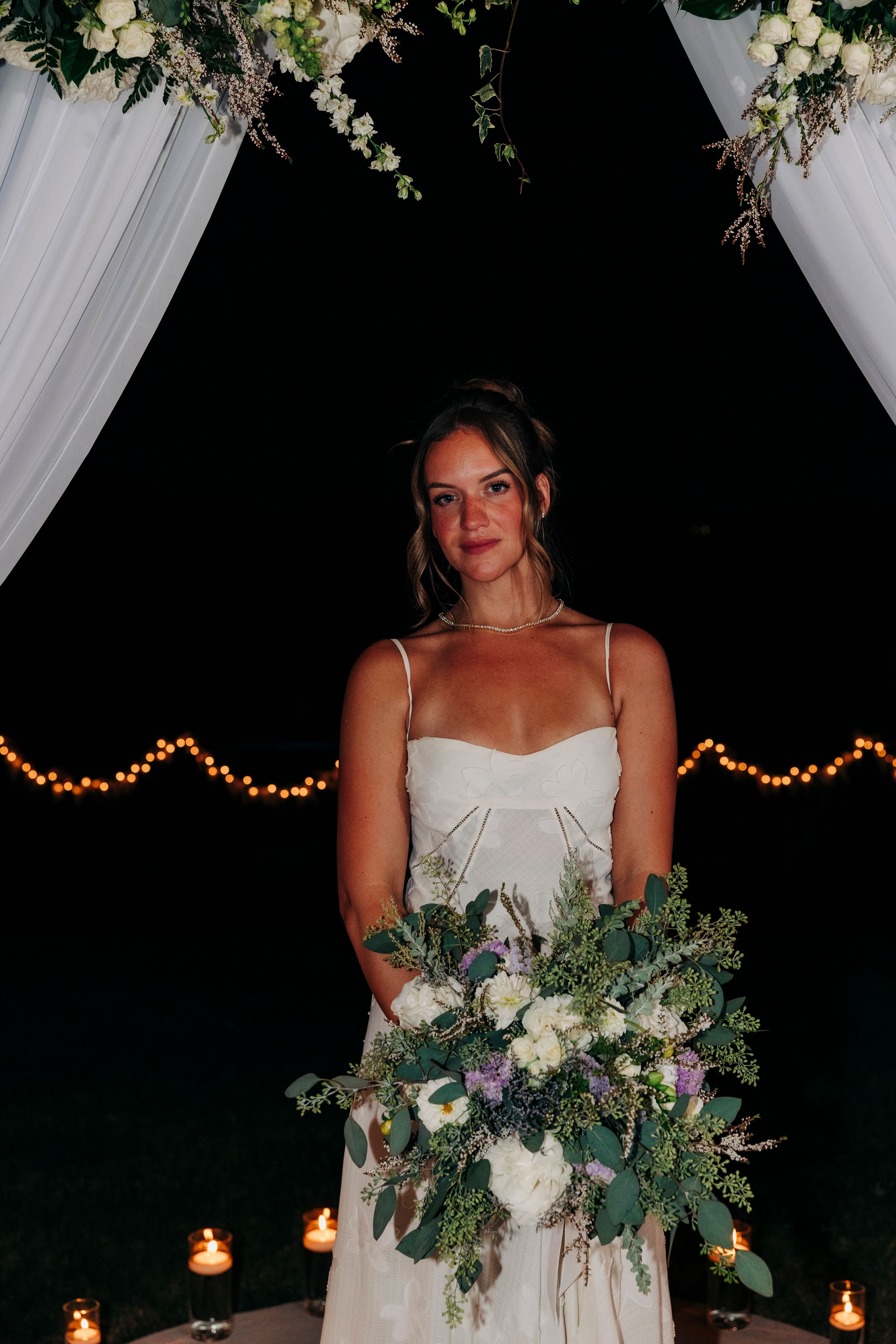 Bride holding white floral and greenery bouquet at backyard summer wedding in Fort Worth, Texas