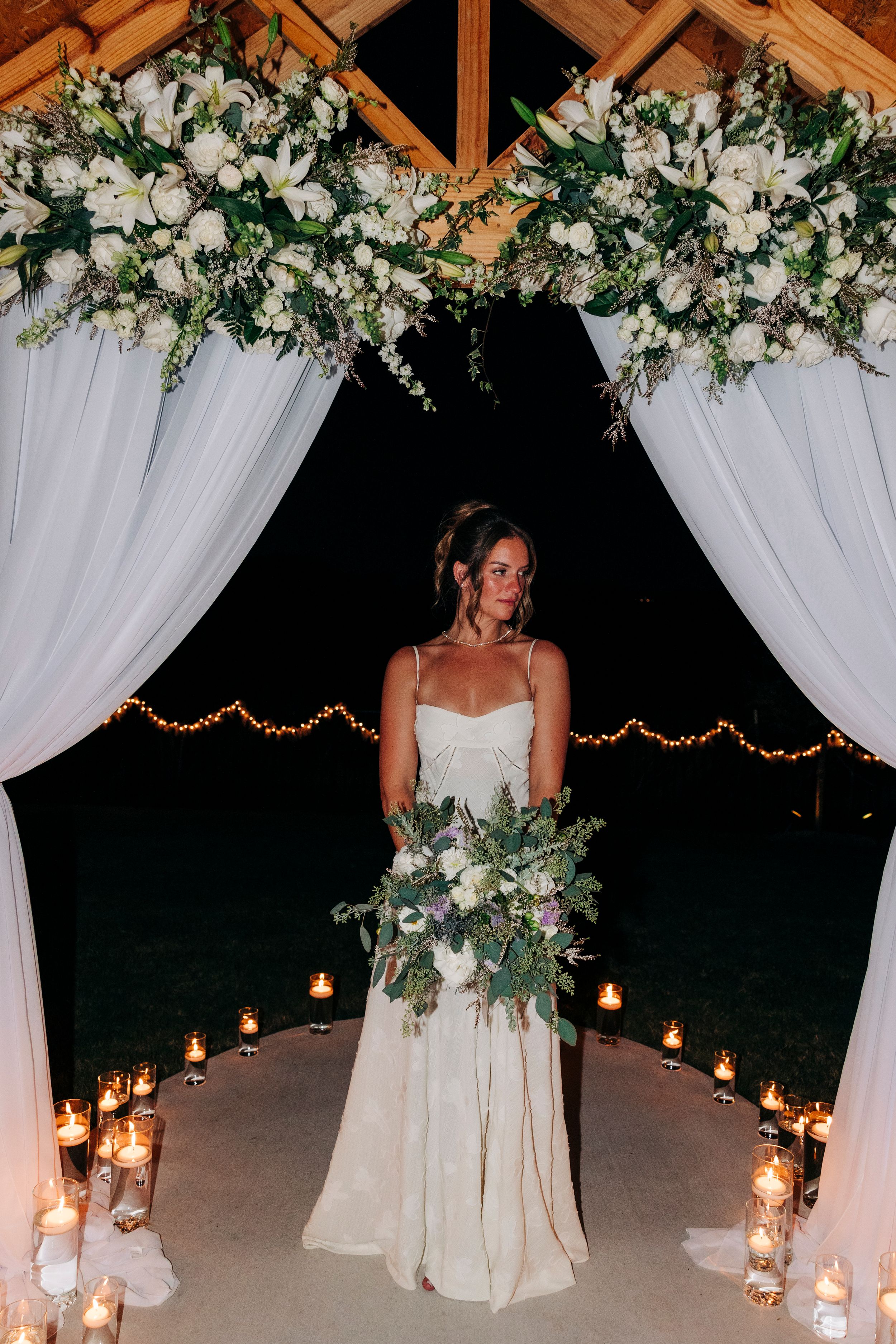 Bride holding white floral and greenery bouquet at backyard summer wedding in Fort Worth, Texas