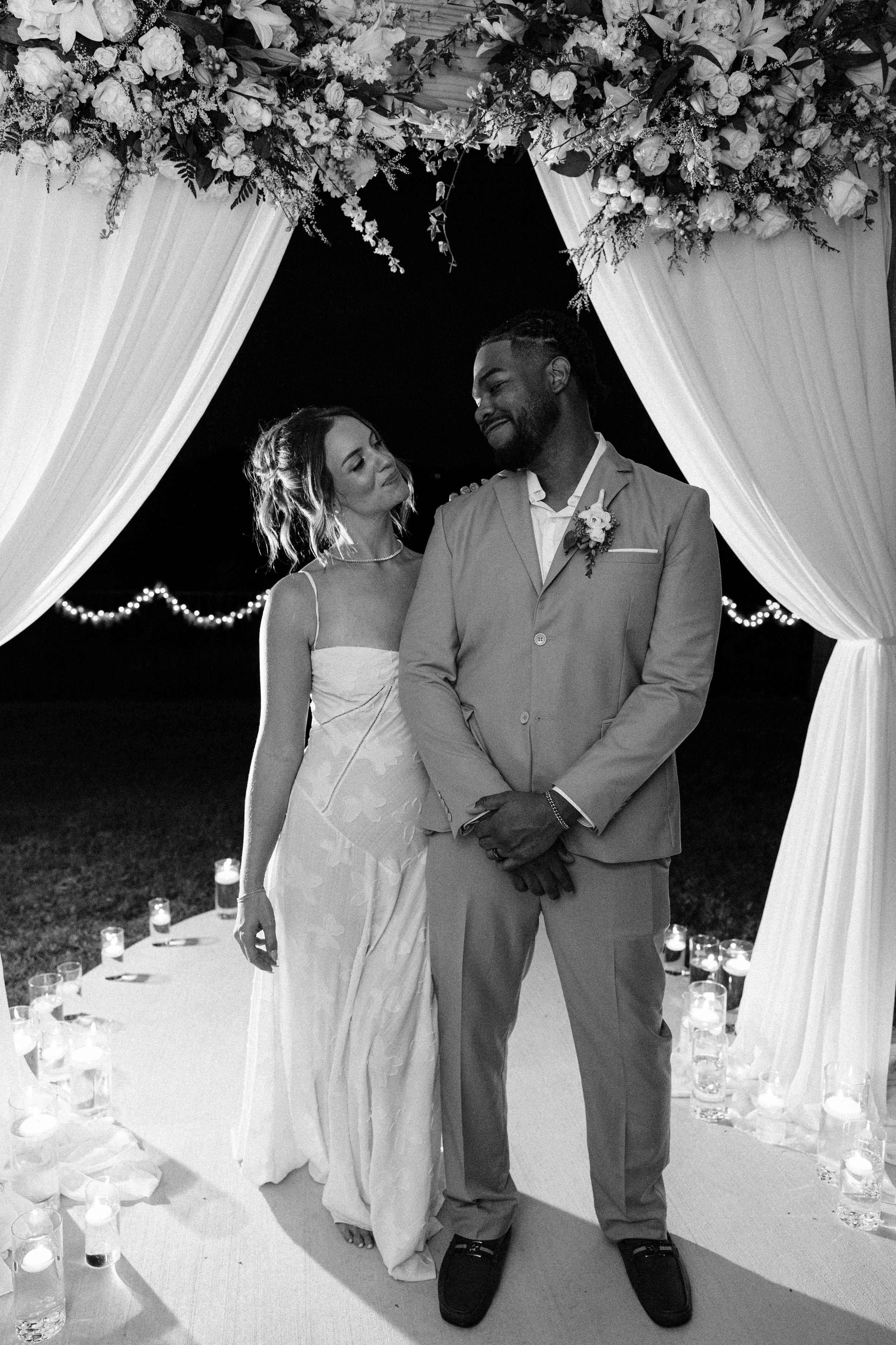 Bride and groom smiling at each other during golden hour at backyard summer wedding in Fort Worth, Texas