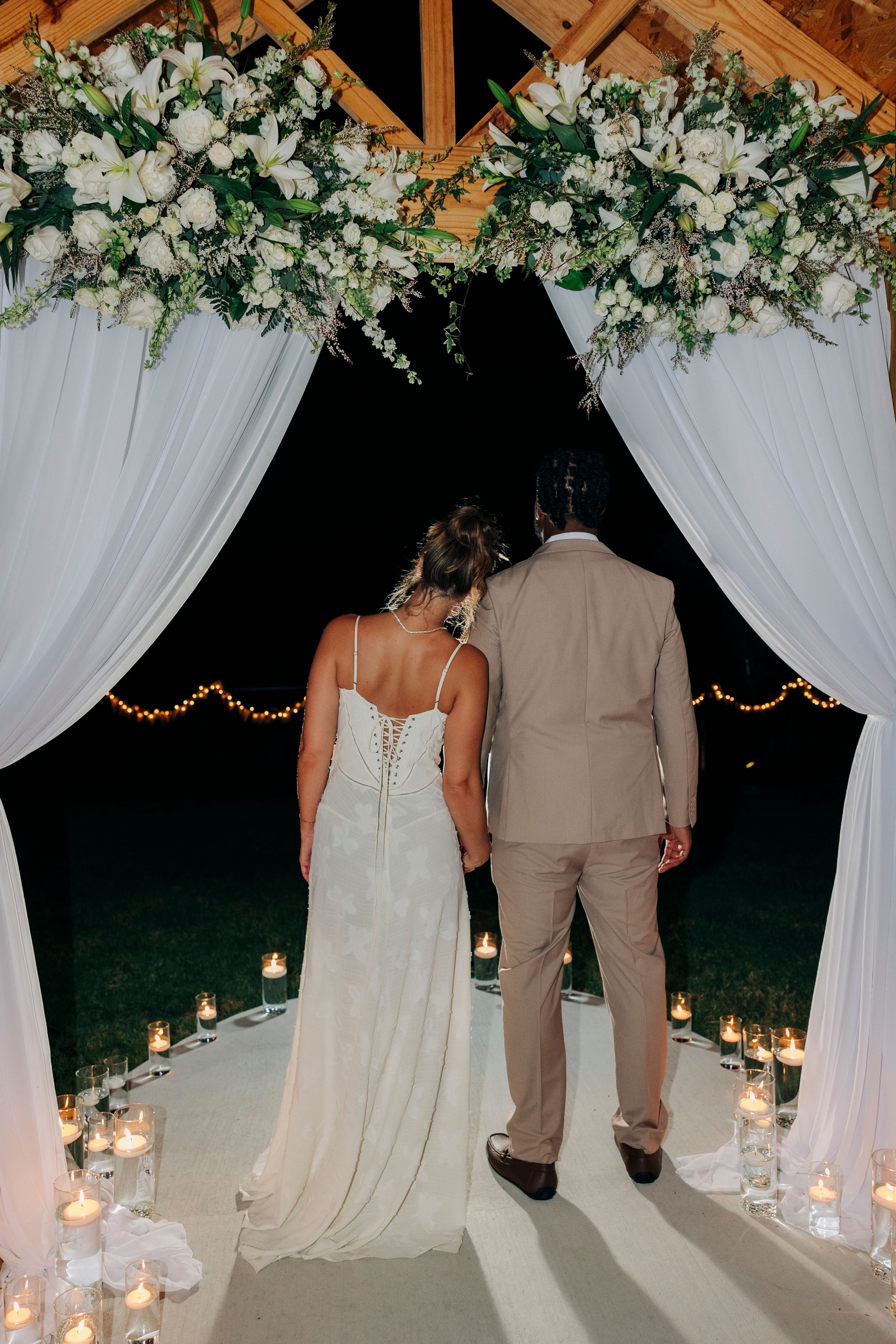 Bride and groom smiling at each other during golden hour at backyard summer wedding in Fort Worth, Texas