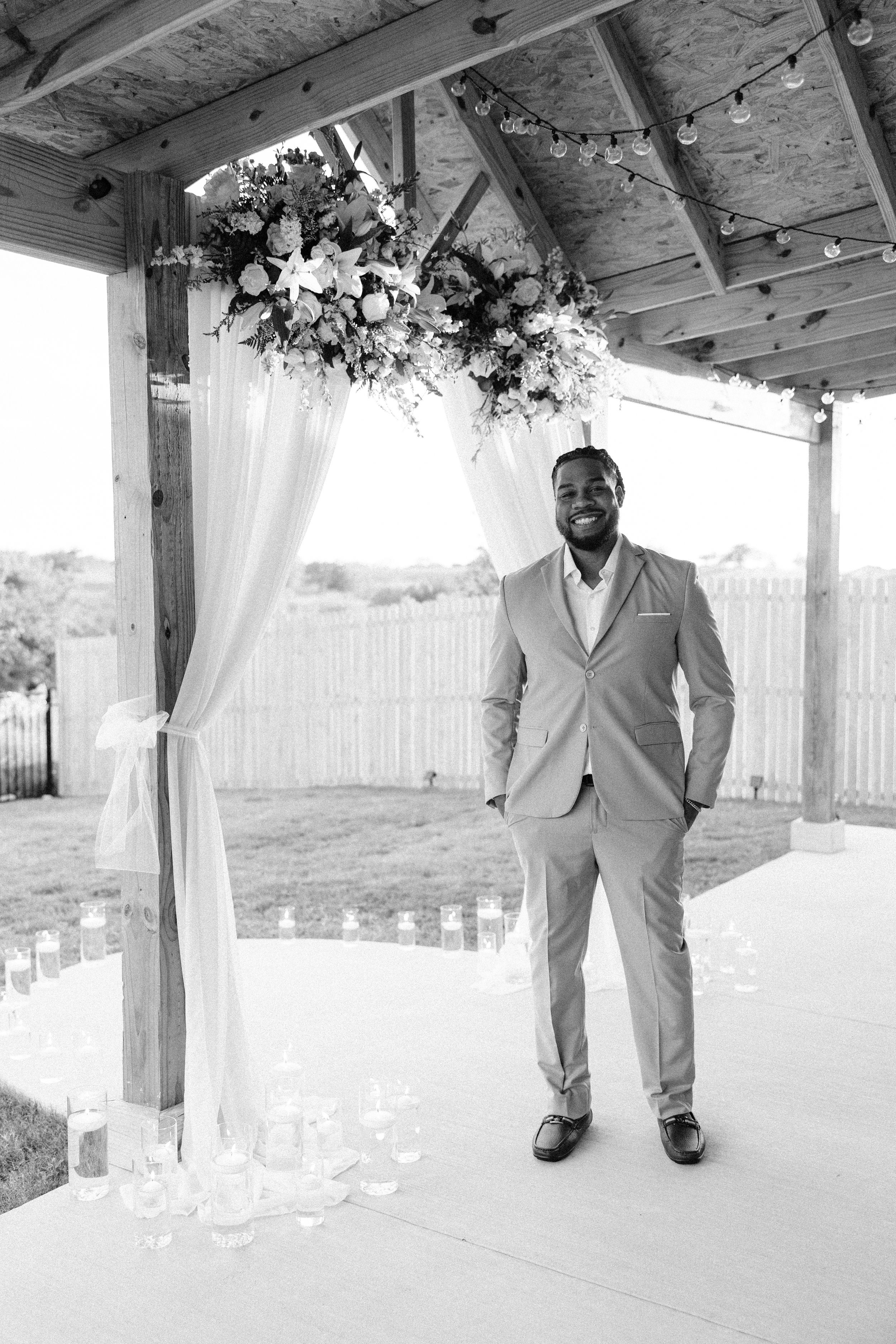 Groom standing at ceremony site waiting for bride during backyard wedding in Fort Worth
