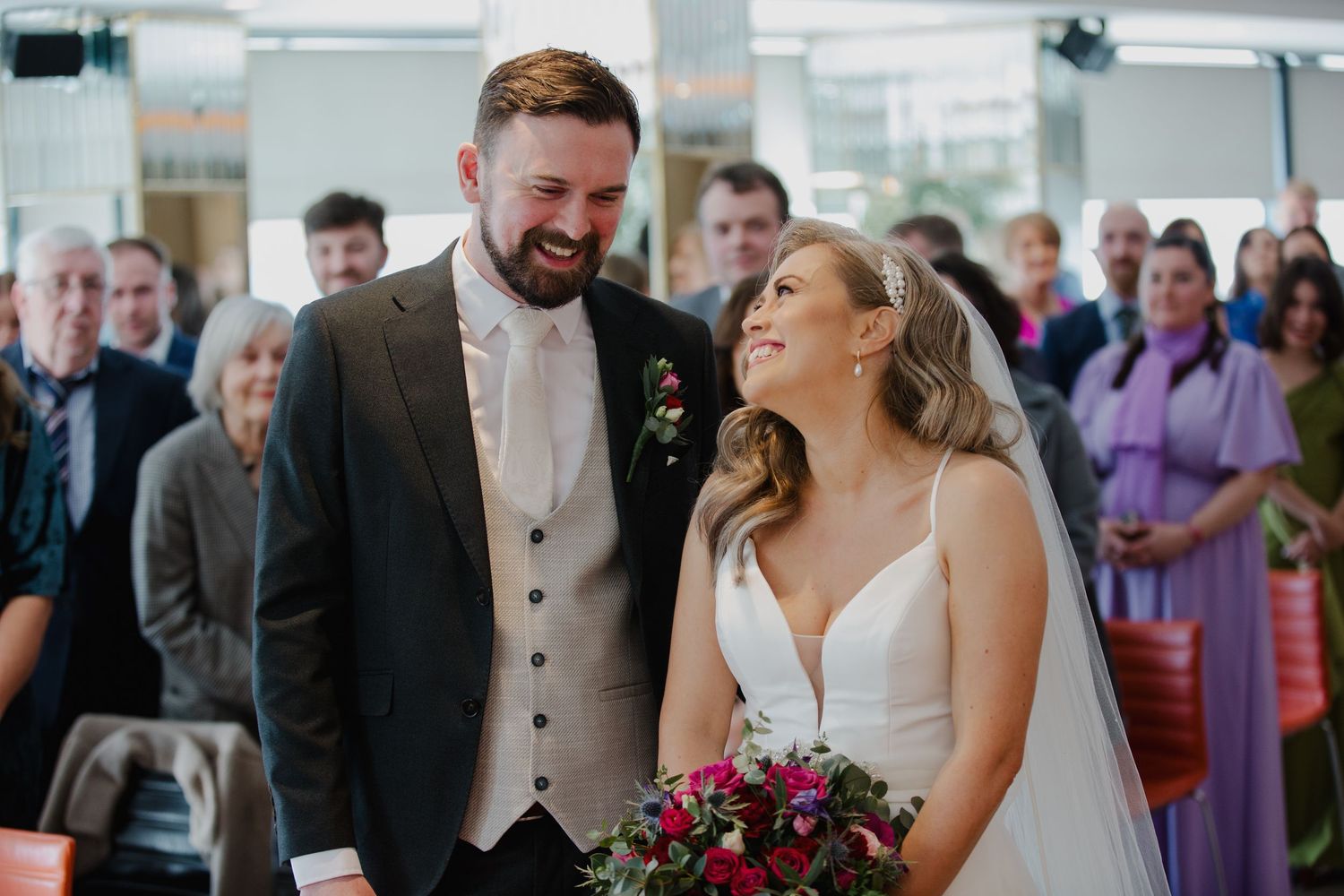 Wedding party celebrating and laughing together during a joyful reception moment.