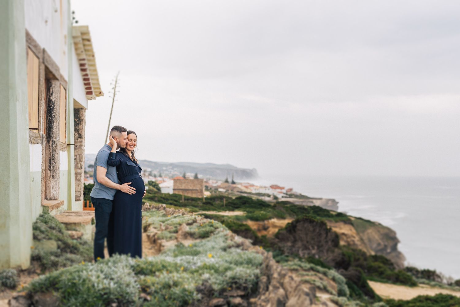 Maternity photoshoot at Azenhas do Mar with a mom-to-be surrounded by coastal cliffs and ocean views