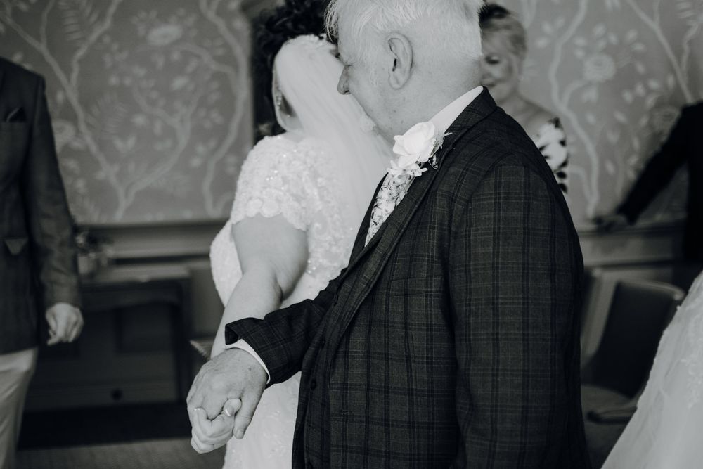 A tender moment between wedding couple sharing a dance at their reception in black and white.