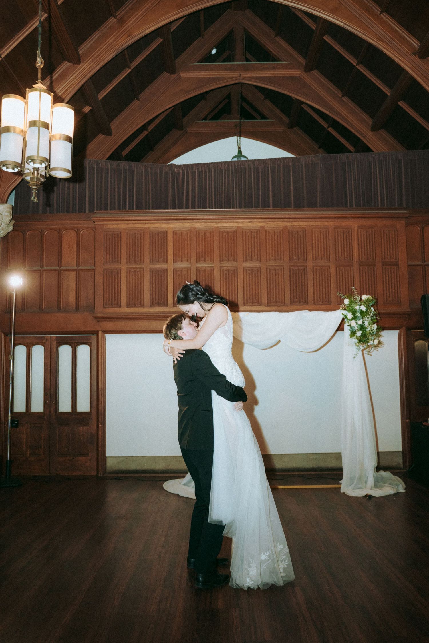 A romantic first dance in a beautiful wooden-beamed reception hall.