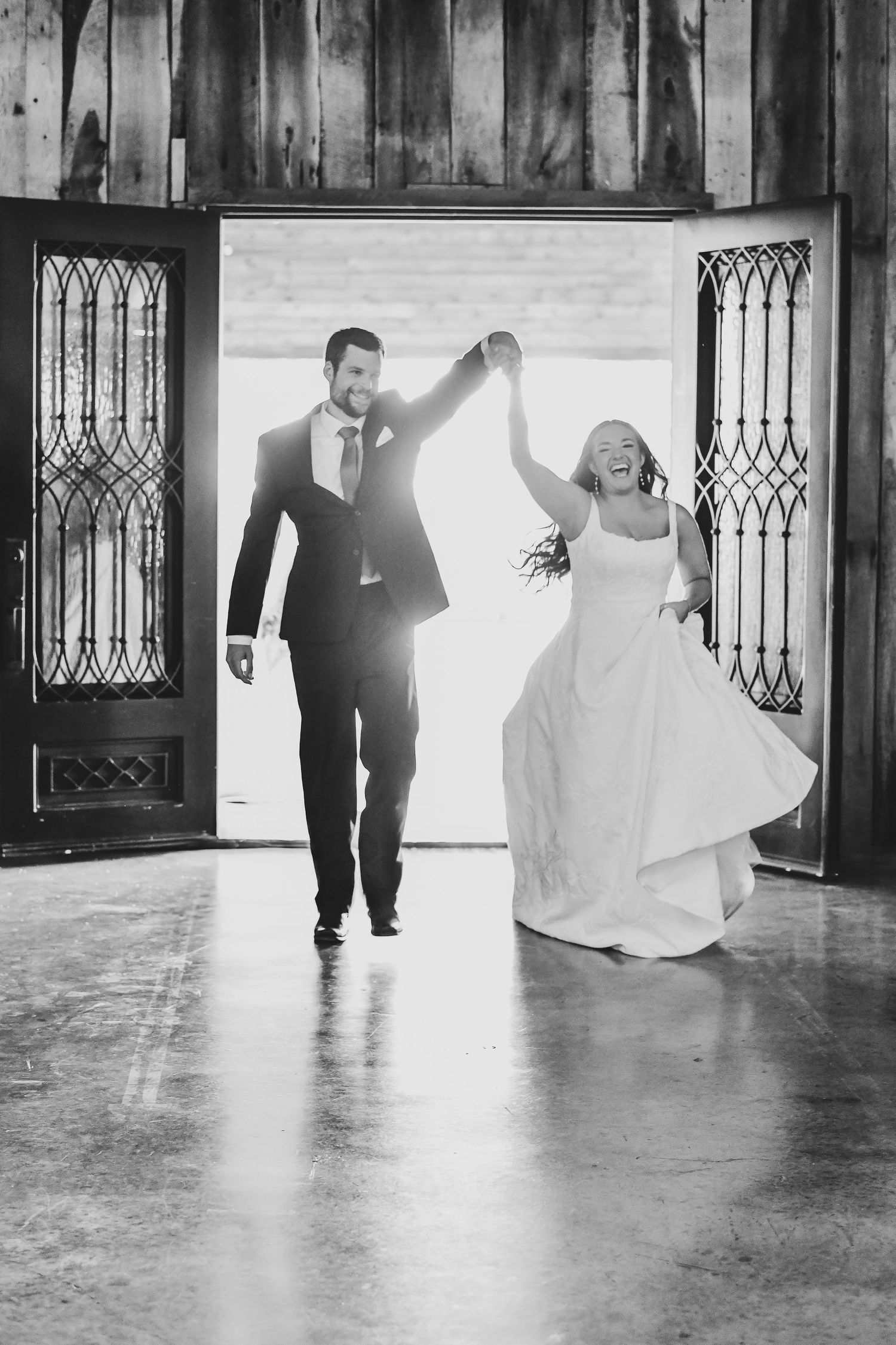 A very excited bride and groom celebrate and dance into their wedding reception to begin their first dance