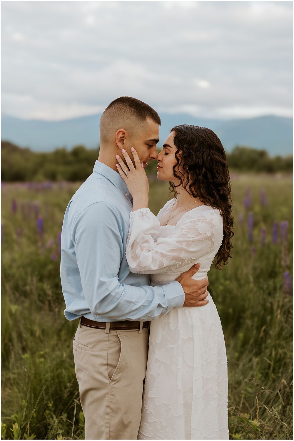 A couple taking engagement pictures in the mountains in NH
