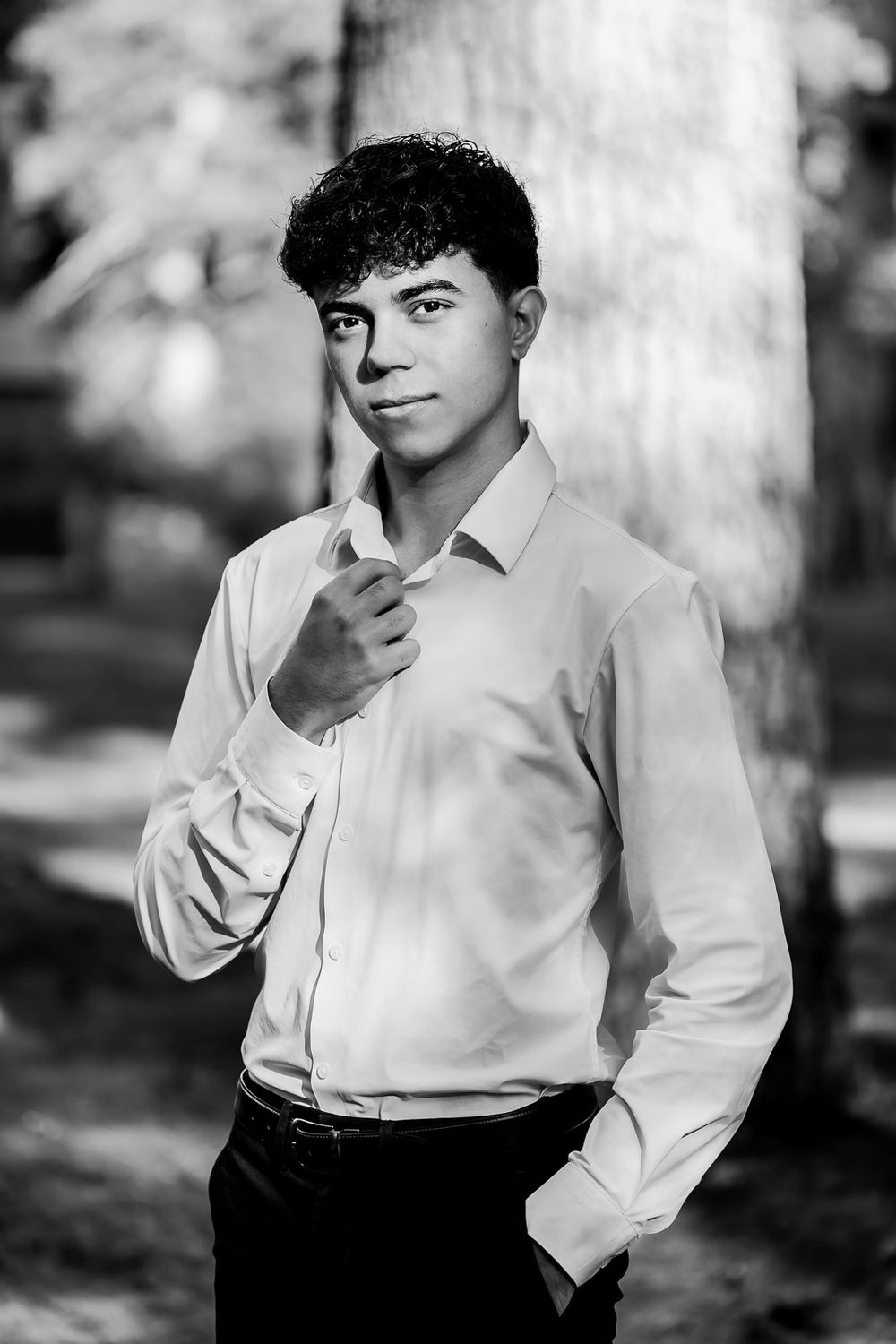 Black and white photo series showing different artistic poses in a white dress shirt against a soft blurred background.