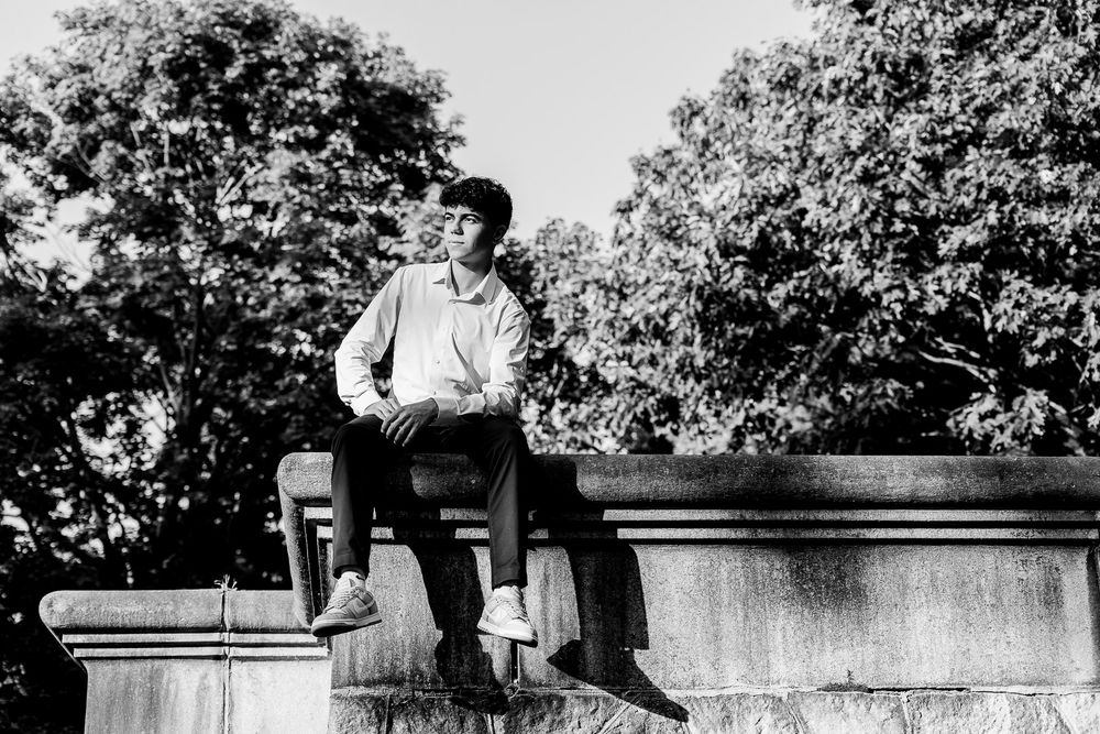 A person is shown jumping over a stone wall in a series of sequential black and white photographs.