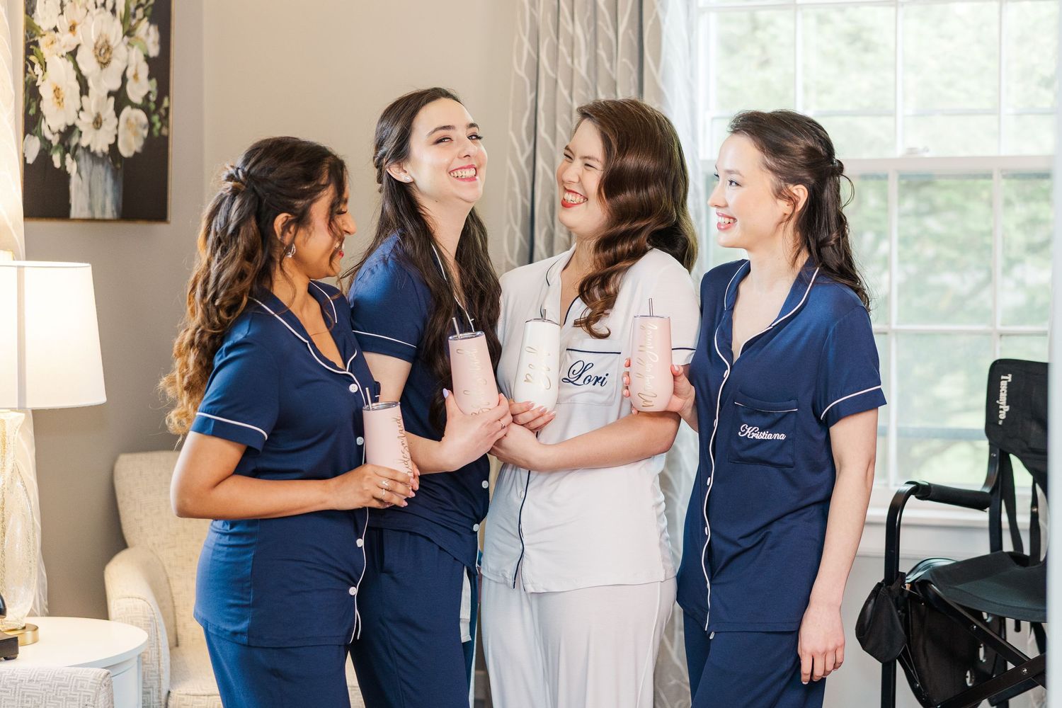 Healthcare team members wearing navy blue and white uniforms share a lighthearted moment while conversing in a medical setting.