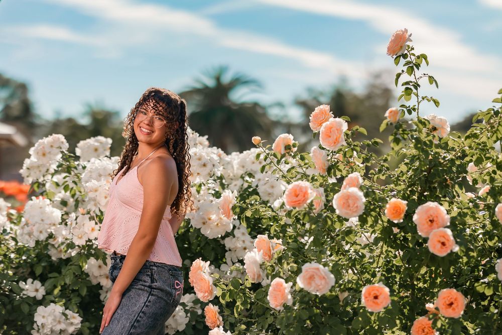 Senior portrait of girl surrounded by roses, Tucson rose garden