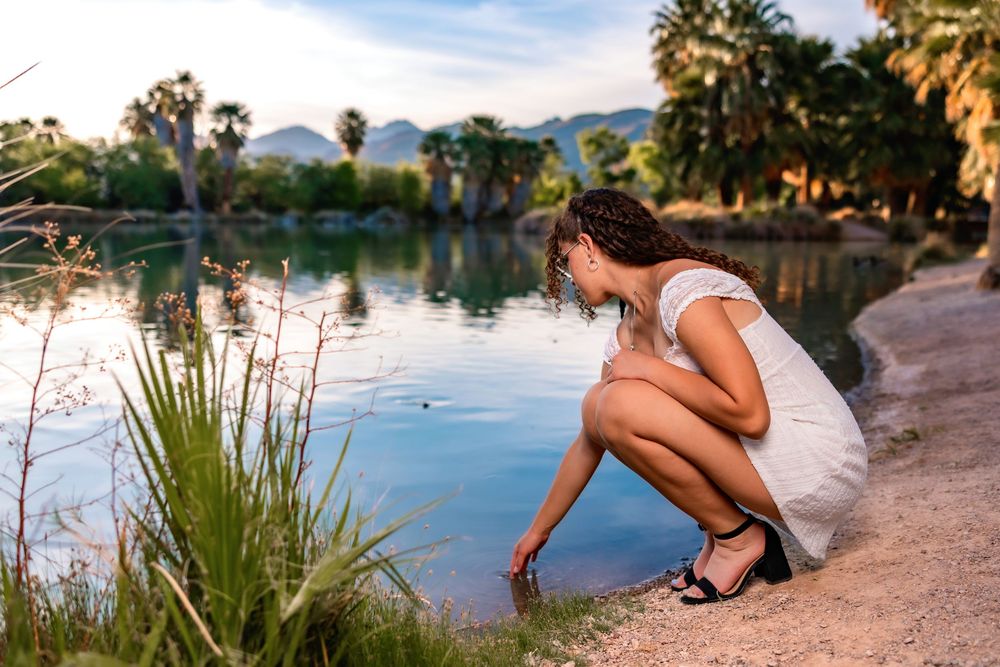 Golden hour senior photo at Agua Caliente Park with palm trees and pond, Tucson, AZ Senior pictures