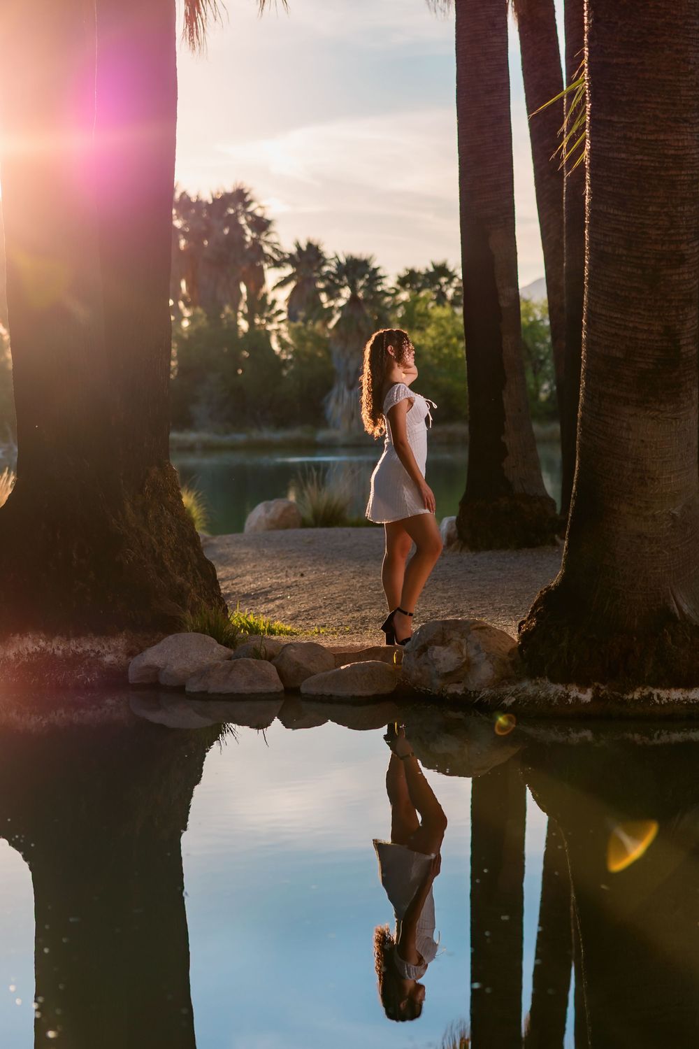 Golden hour senior photo at Agua Caliente Park with palm trees and pond, Tucson, AZ Senior pictures