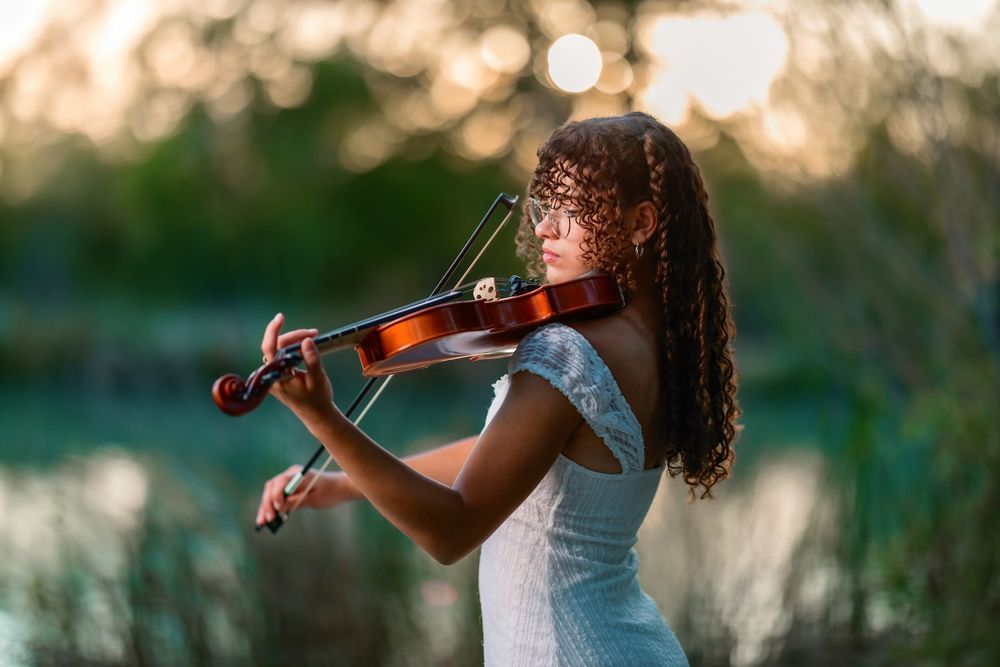 Senior holding violin with soft sunlight at Agua Caliente Park, senior pictures Tucson, AZ
