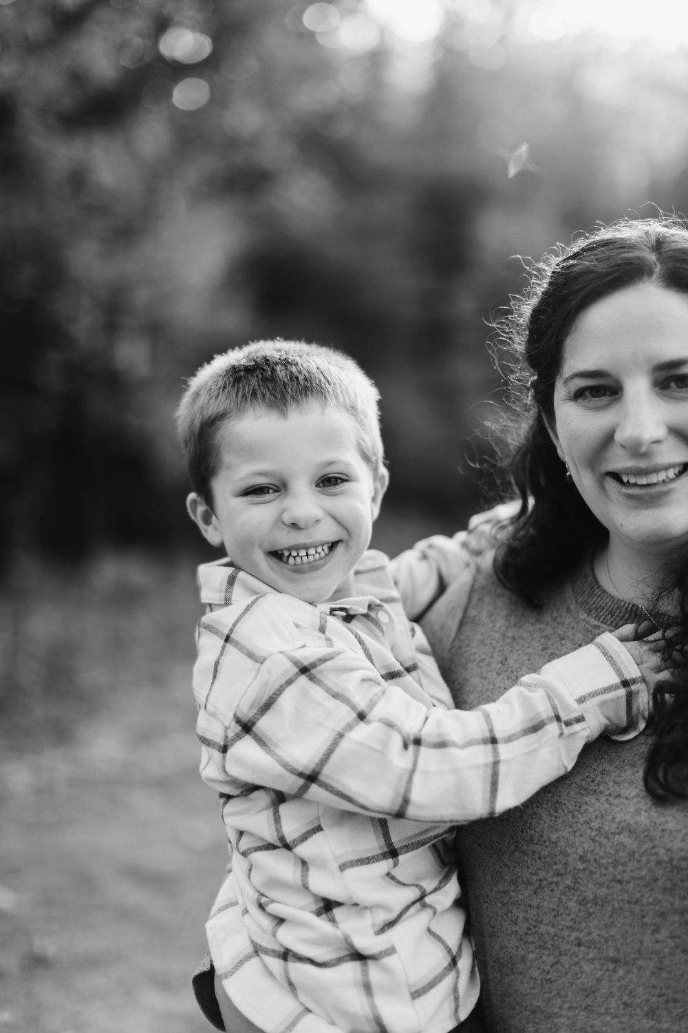 Black and white portrait capturing joyful expressions and genuine connection in an outdoor setting.